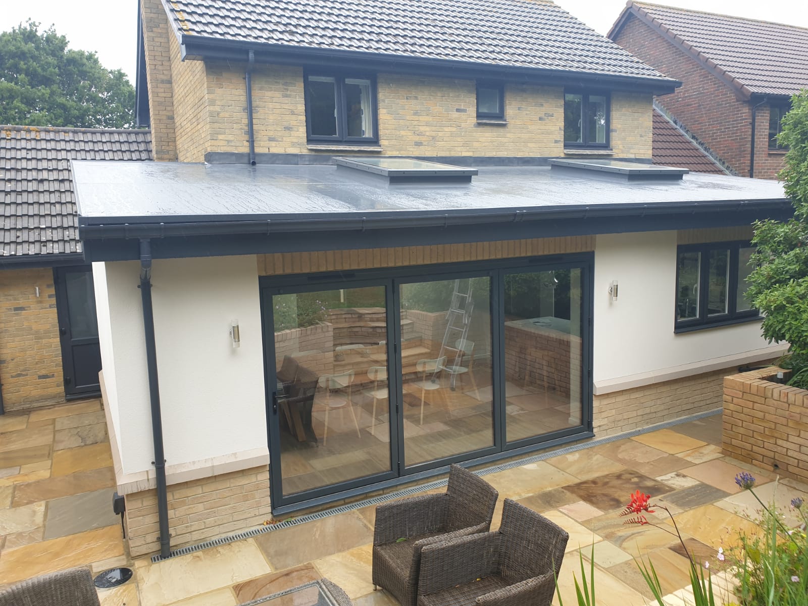 The back of a house with sliding glass doors and a patio area.
