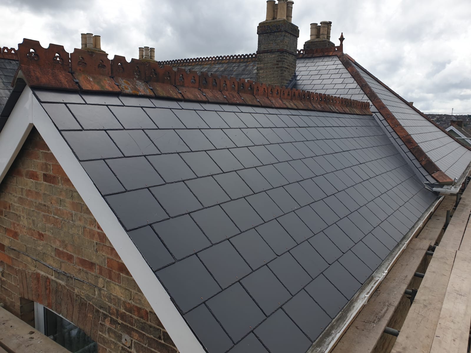 A brick building with a slate roof and chimneys