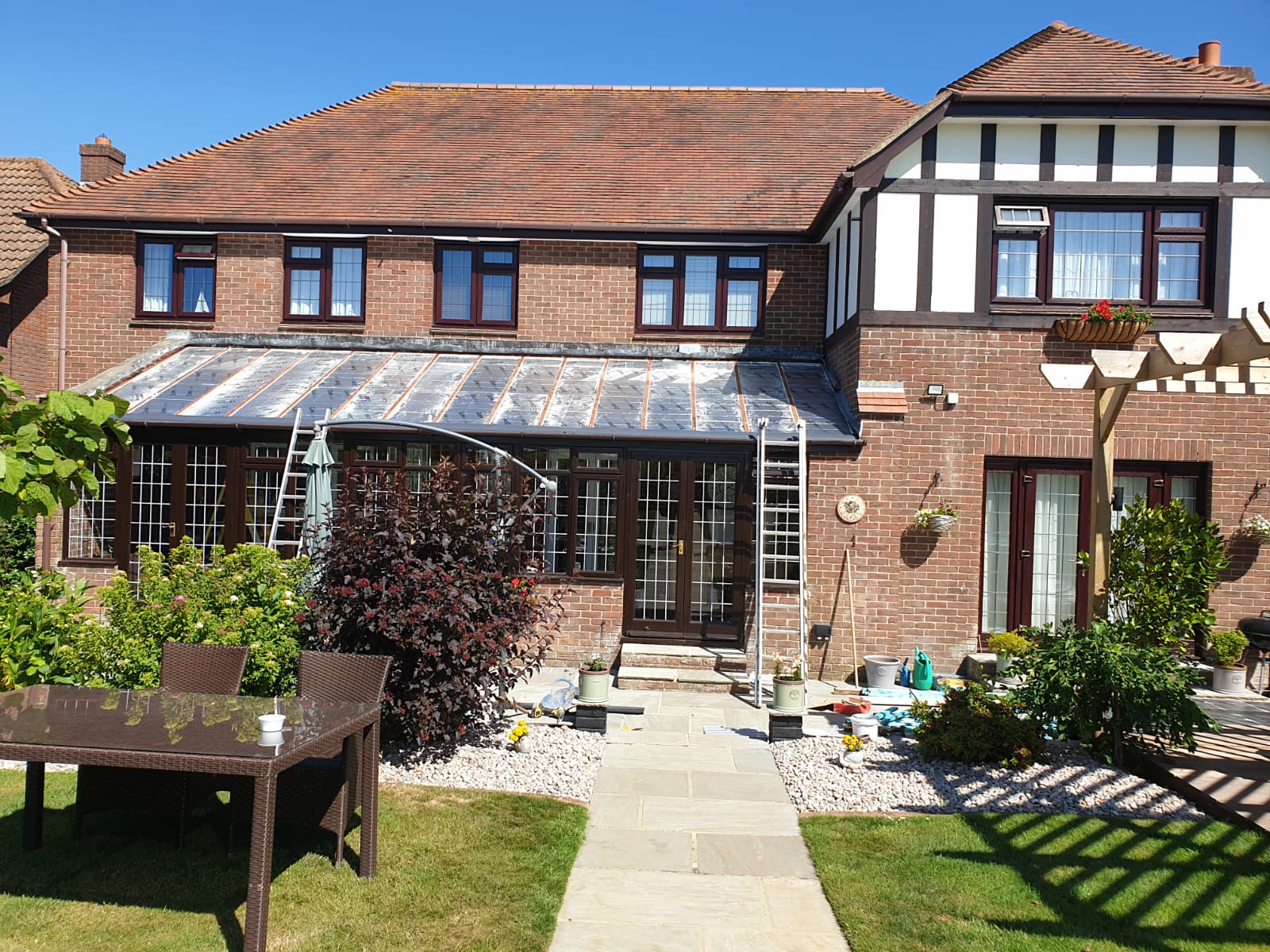 A large brick house with a walkway leading to it and a table and chairs in front of it.