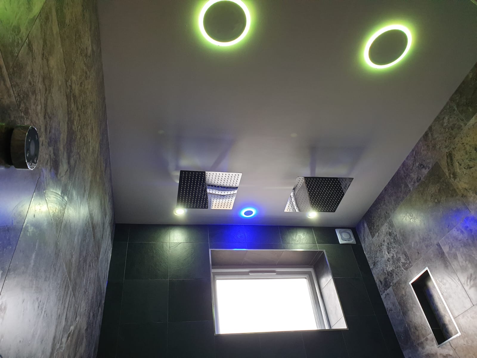 A bathroom with a ceiling that has circles on it and a window.
