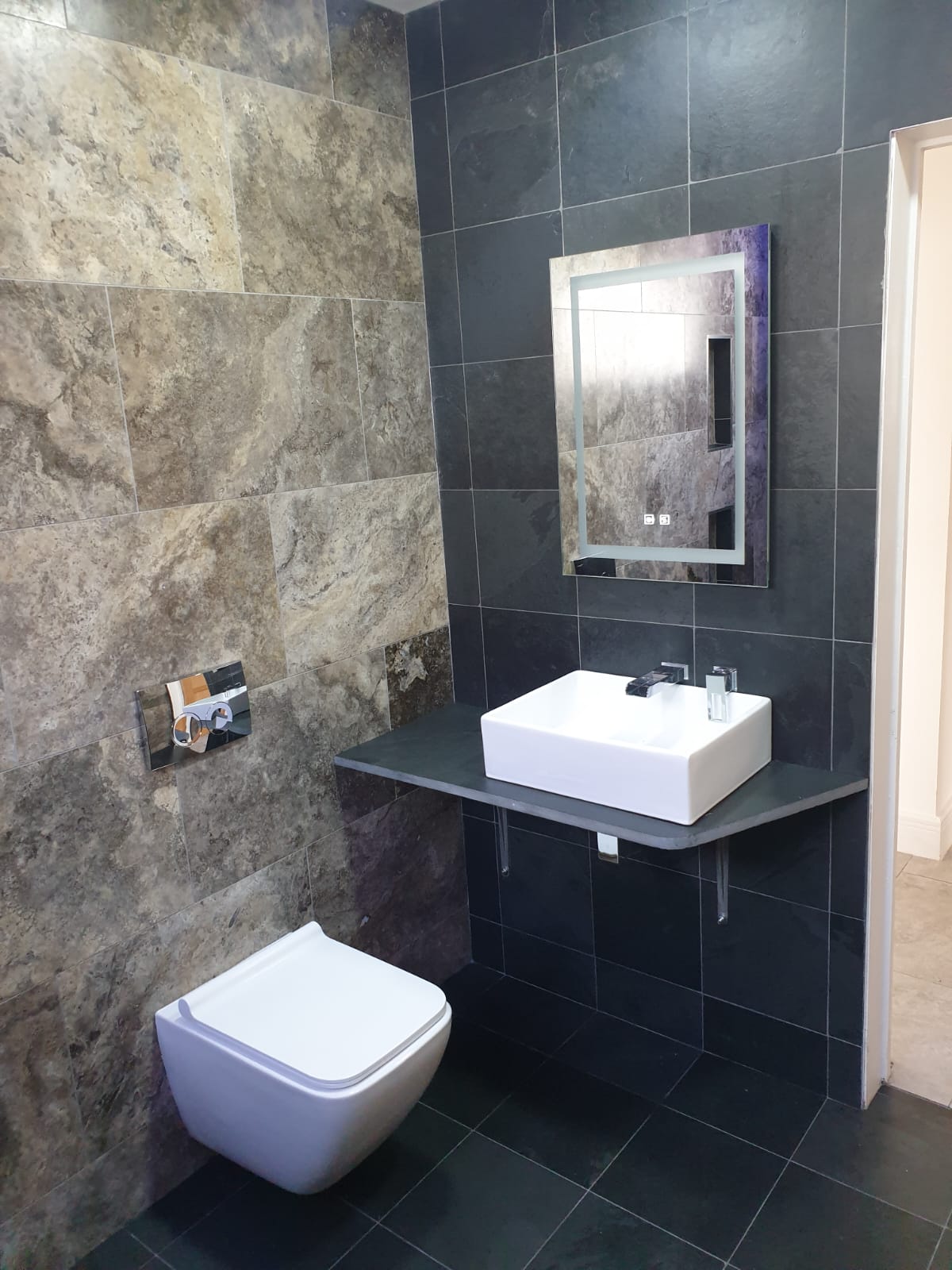 A bathroom with a toilet a sink and a mirror