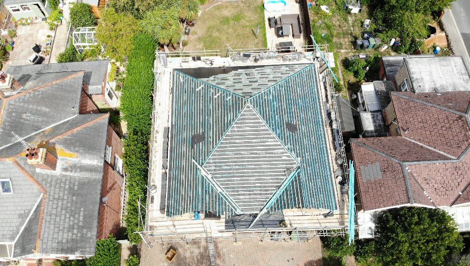 An aerial view of a roof under construction in a residential area.