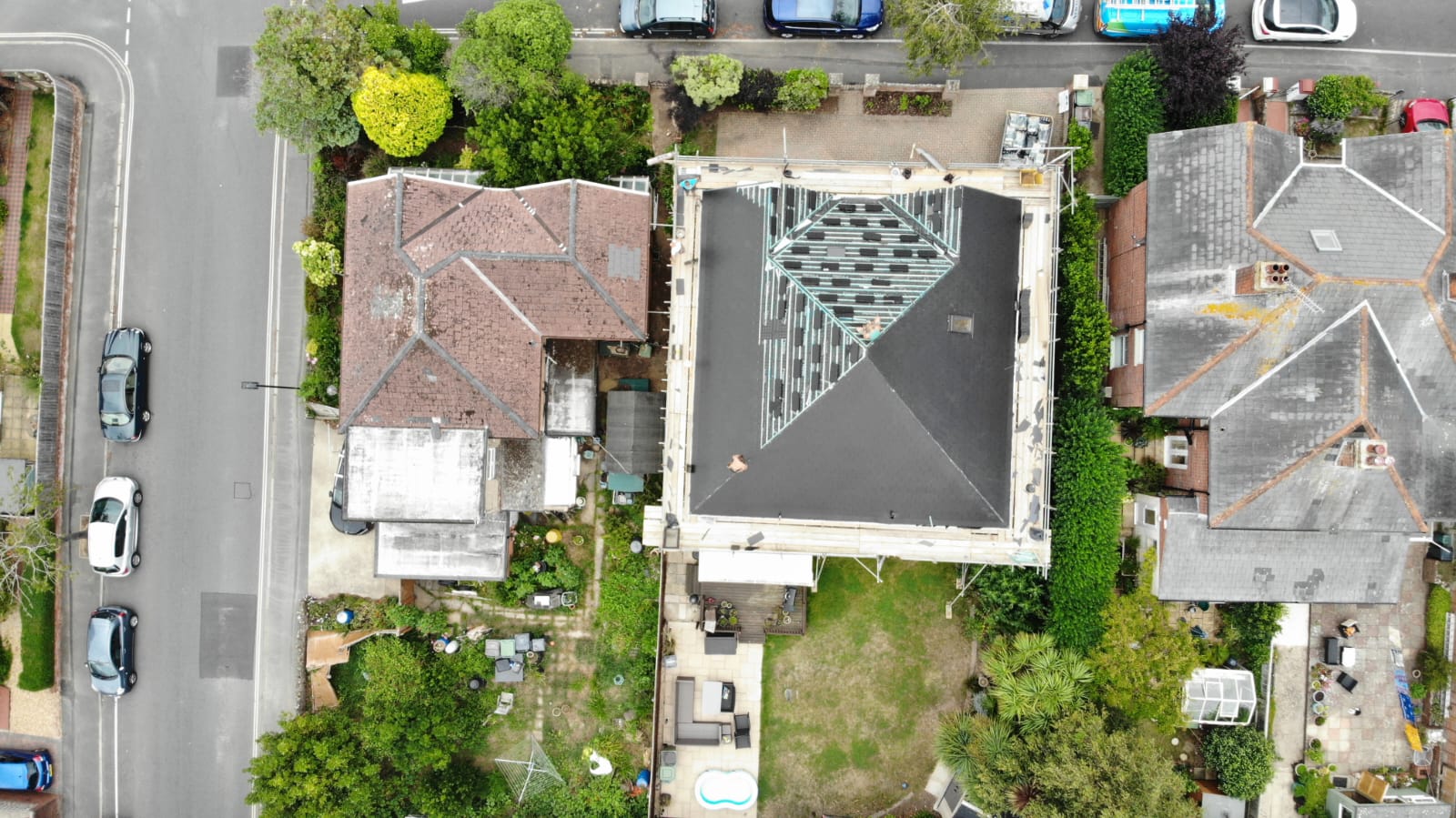 An aerial view of a residential area with houses , cars , and trees.