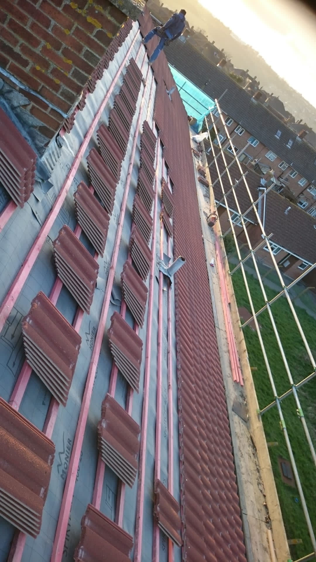 A man is standing on the roof of a building.