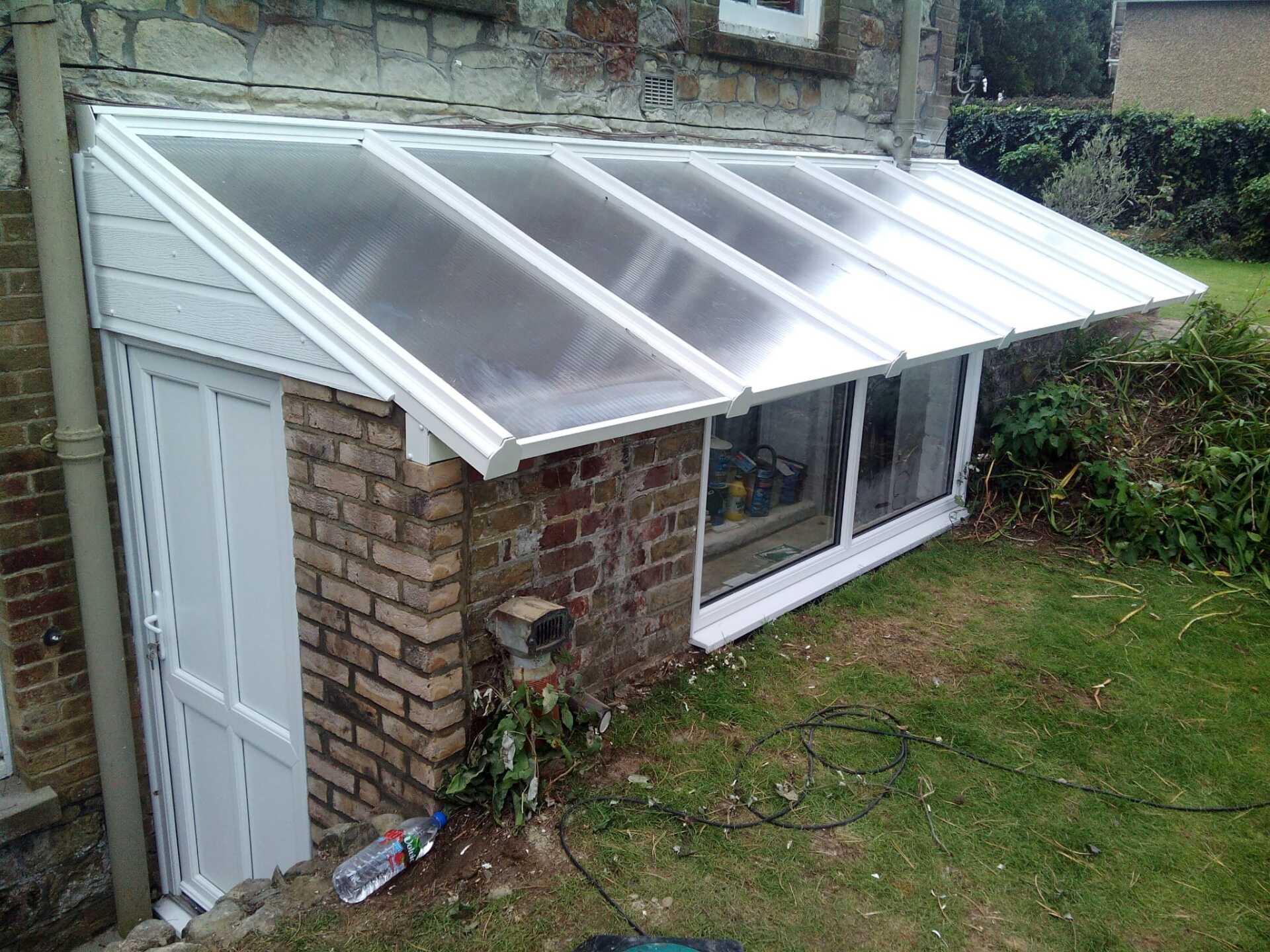 A brick building with a canopy over the door and window.