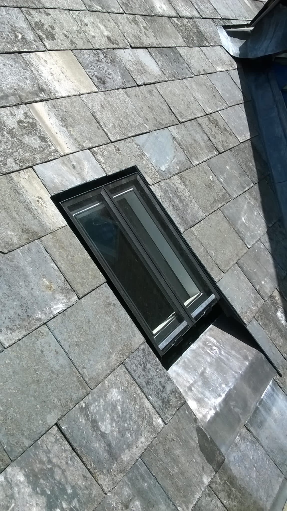 A close up of a window on a brick roof.