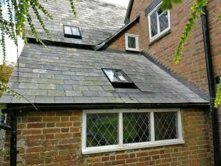 A brick building with a slate roof and two skylights.