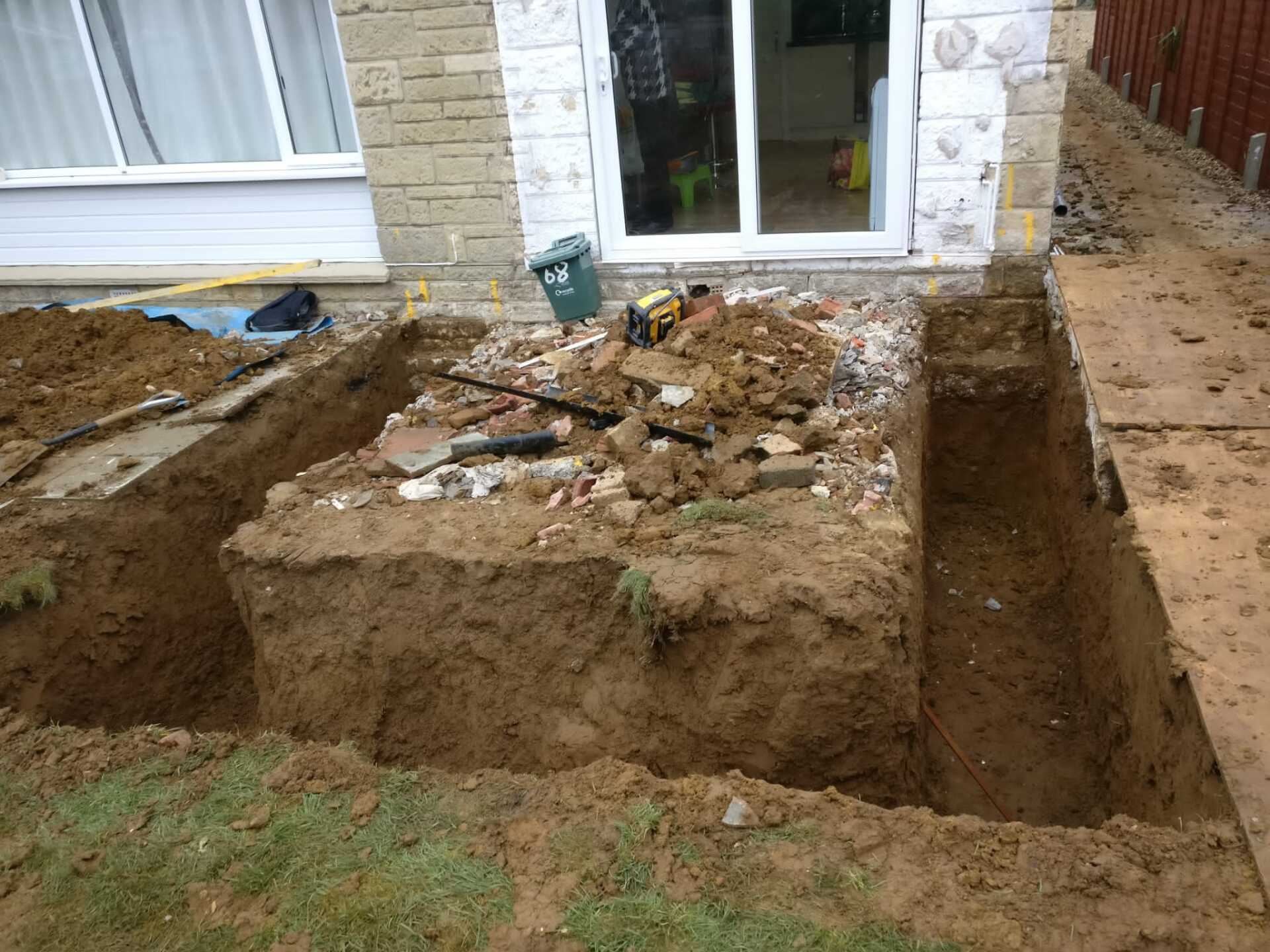 A large pile of dirt is sitting in front of a house.