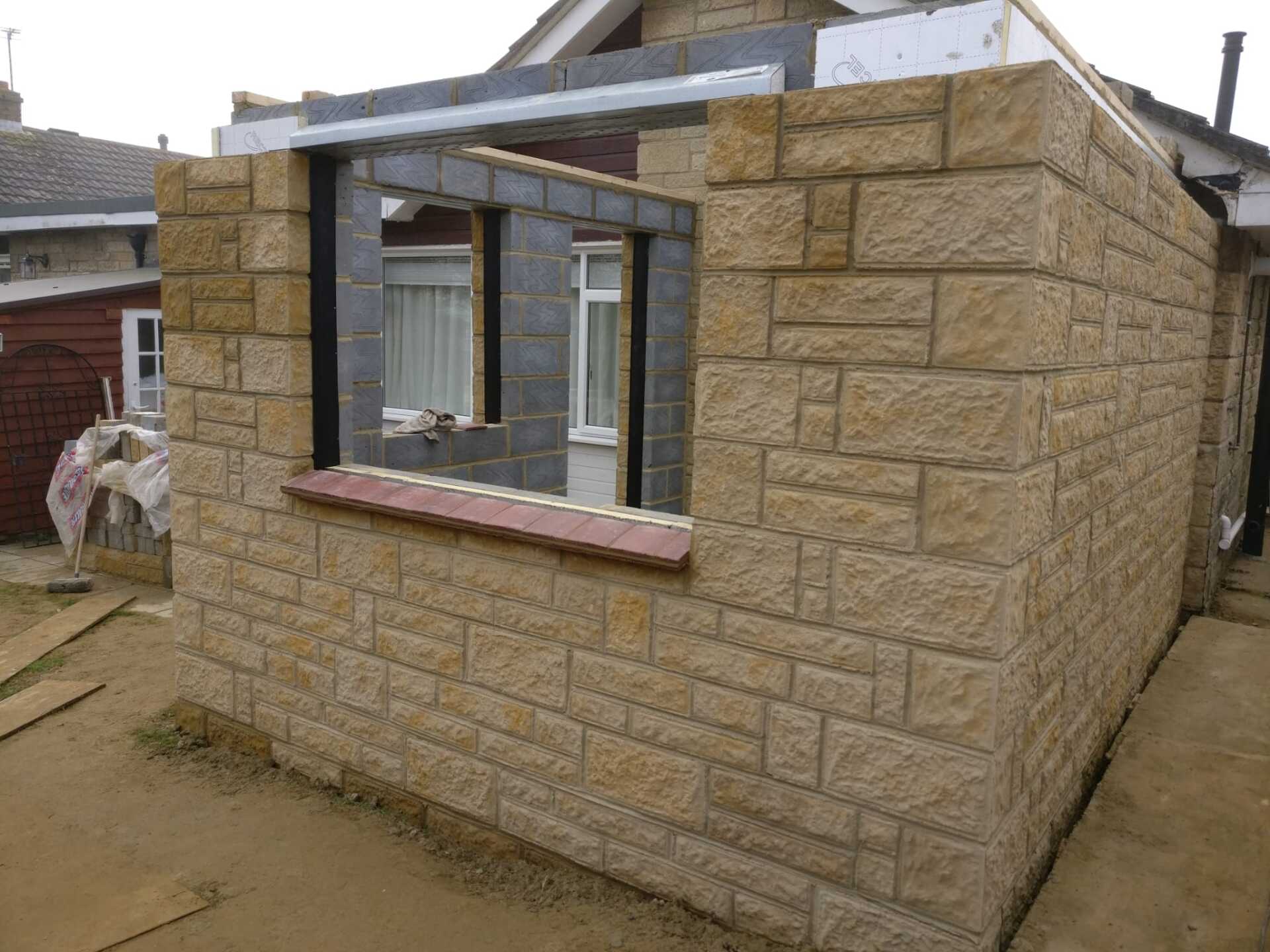 A brick building with a window in it is being built.