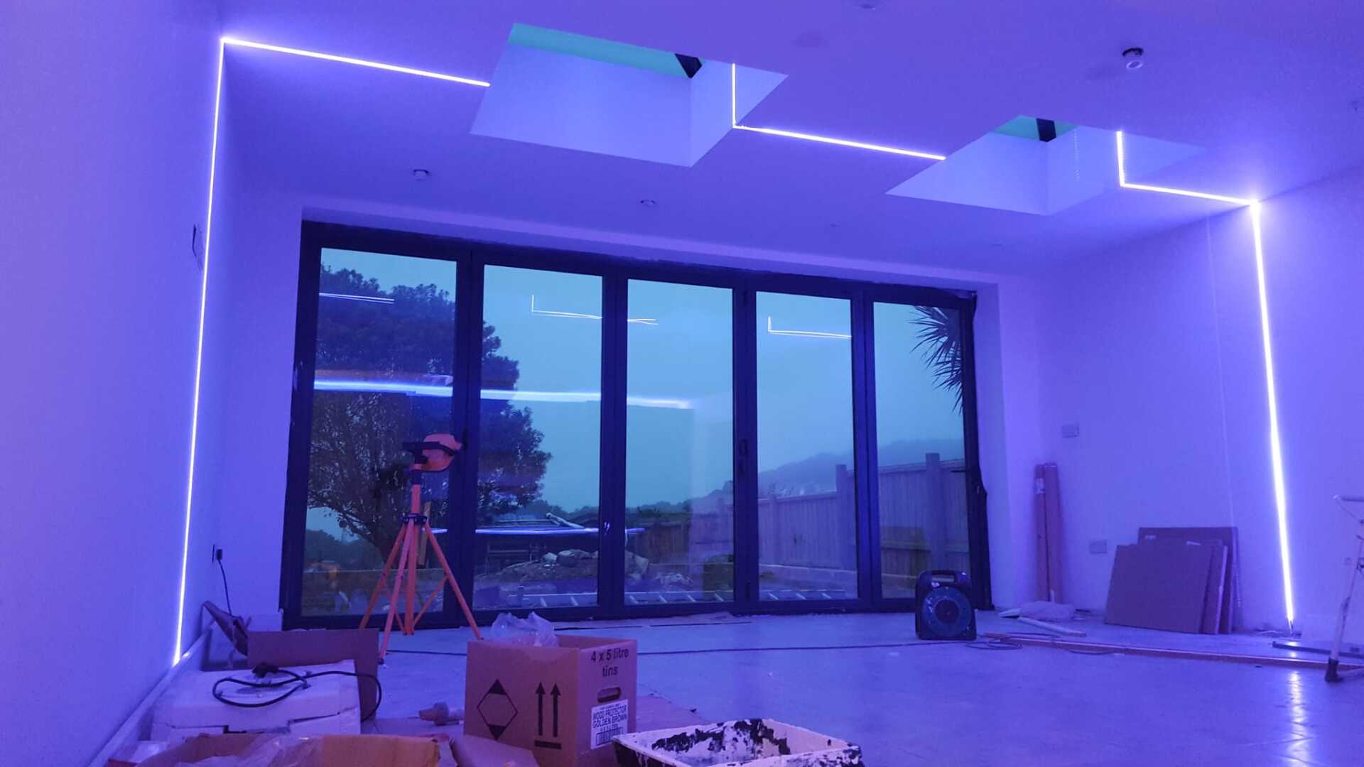 A room with a lot of windows and purple lights on the ceiling.