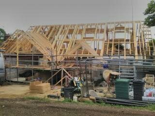 A house is being built with a wooden roof and scaffolding.
