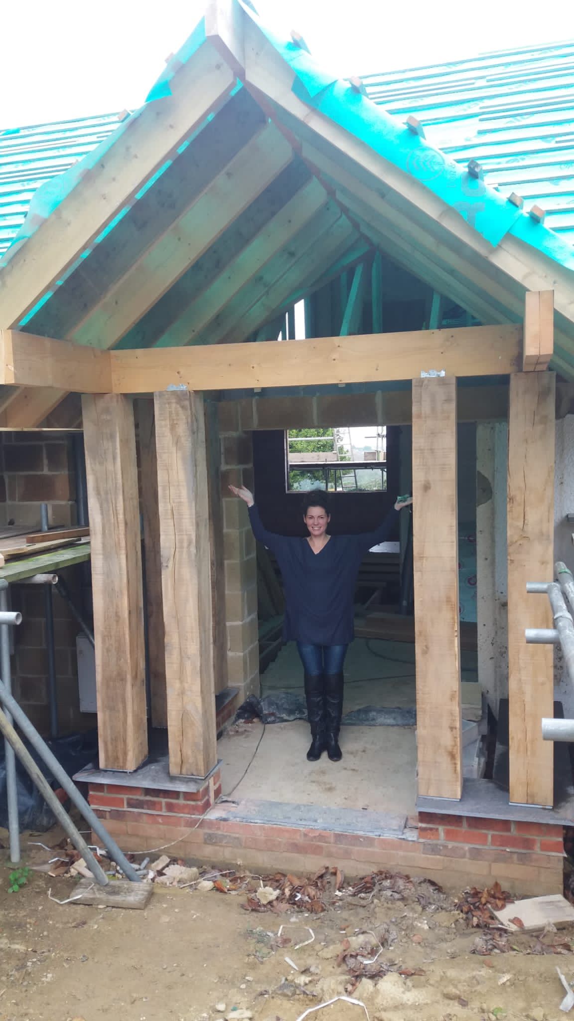 A woman is standing in the doorway of a building under construction.