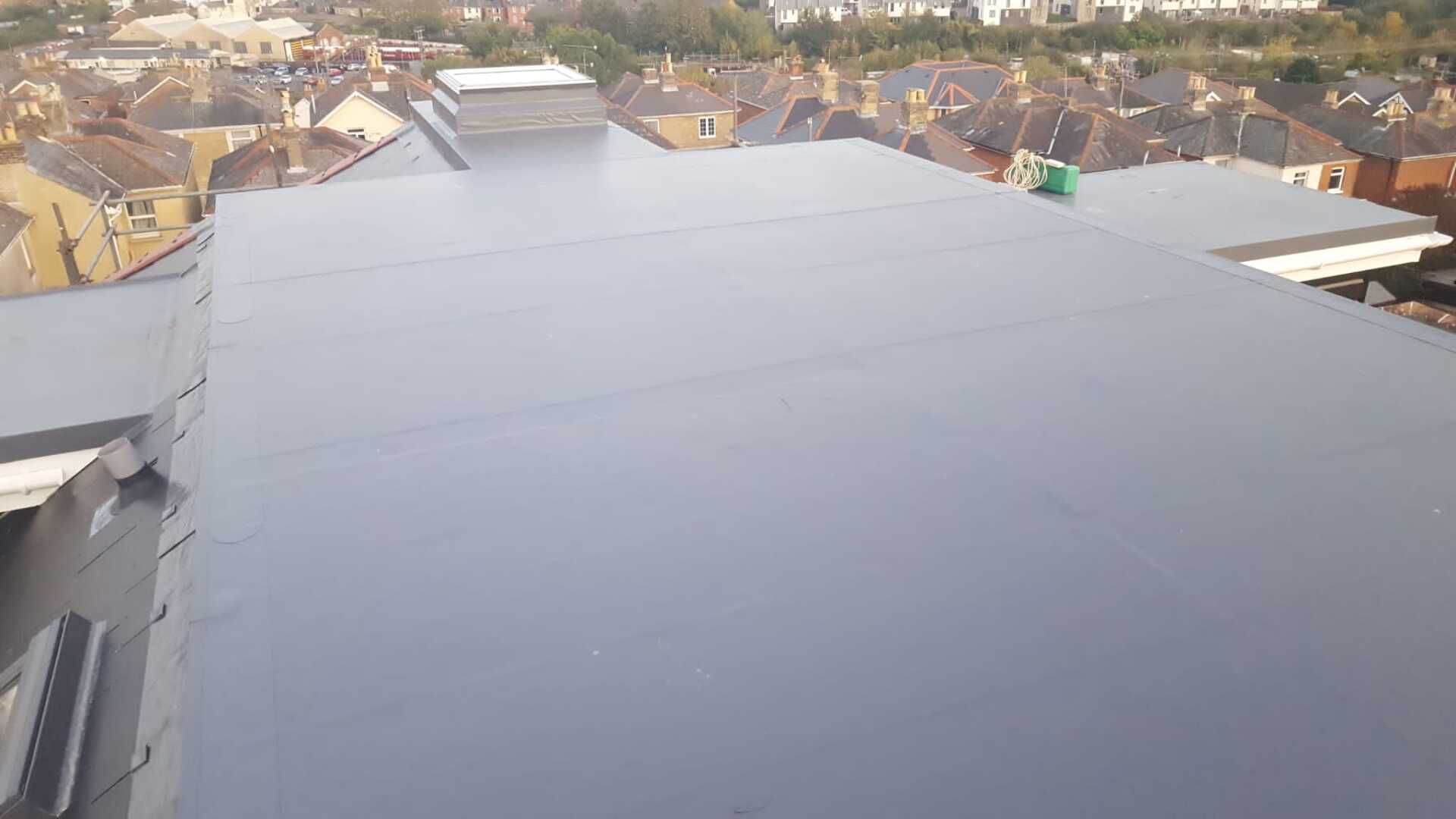 A black roof with a view of a city in the background.