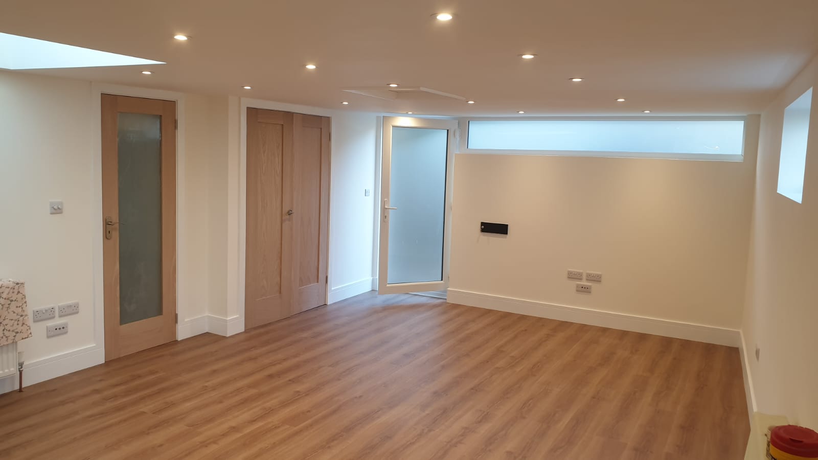 A large empty room with wooden floors and white walls.