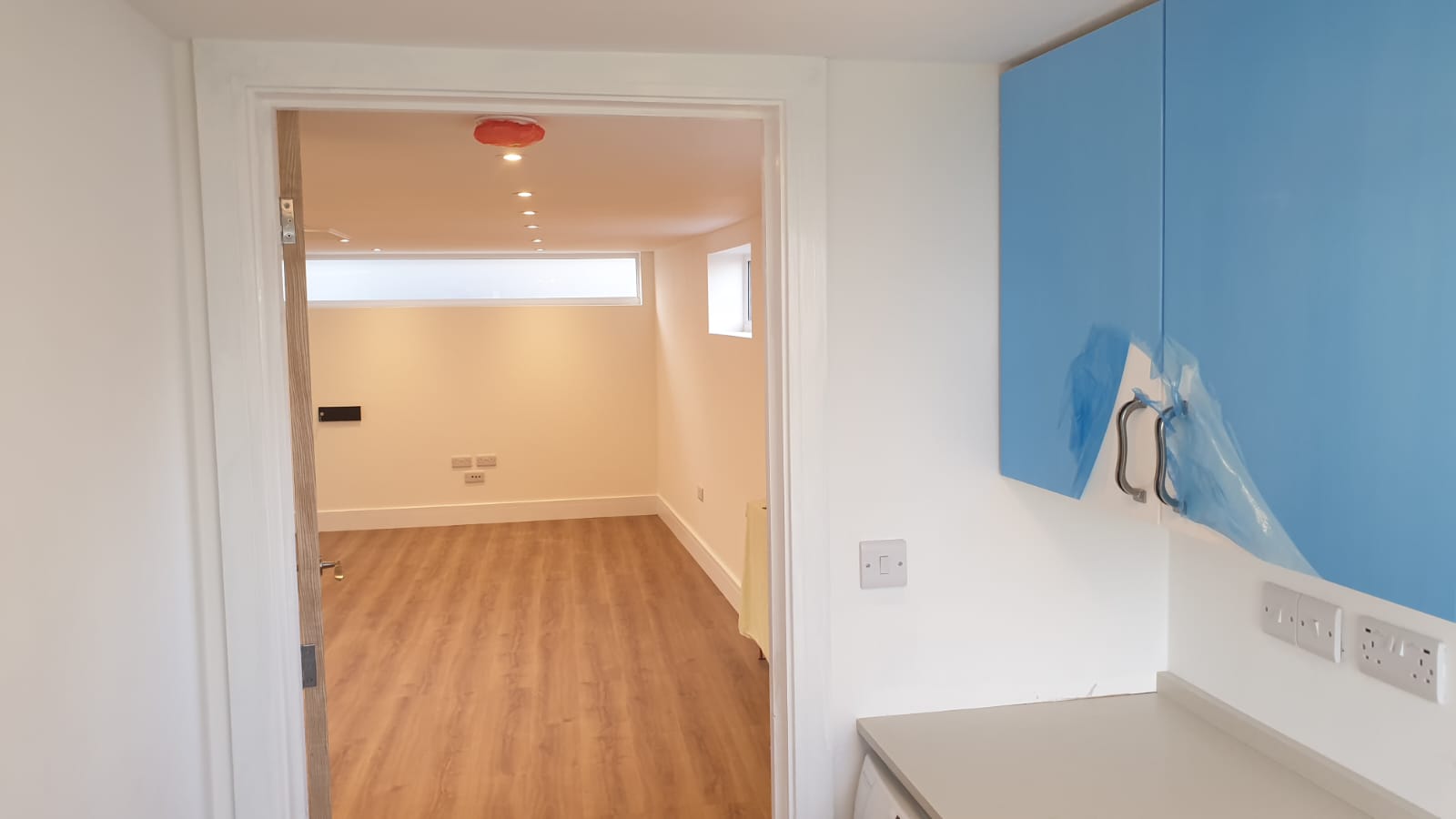 A kitchen with blue cabinets and a wooden floor.