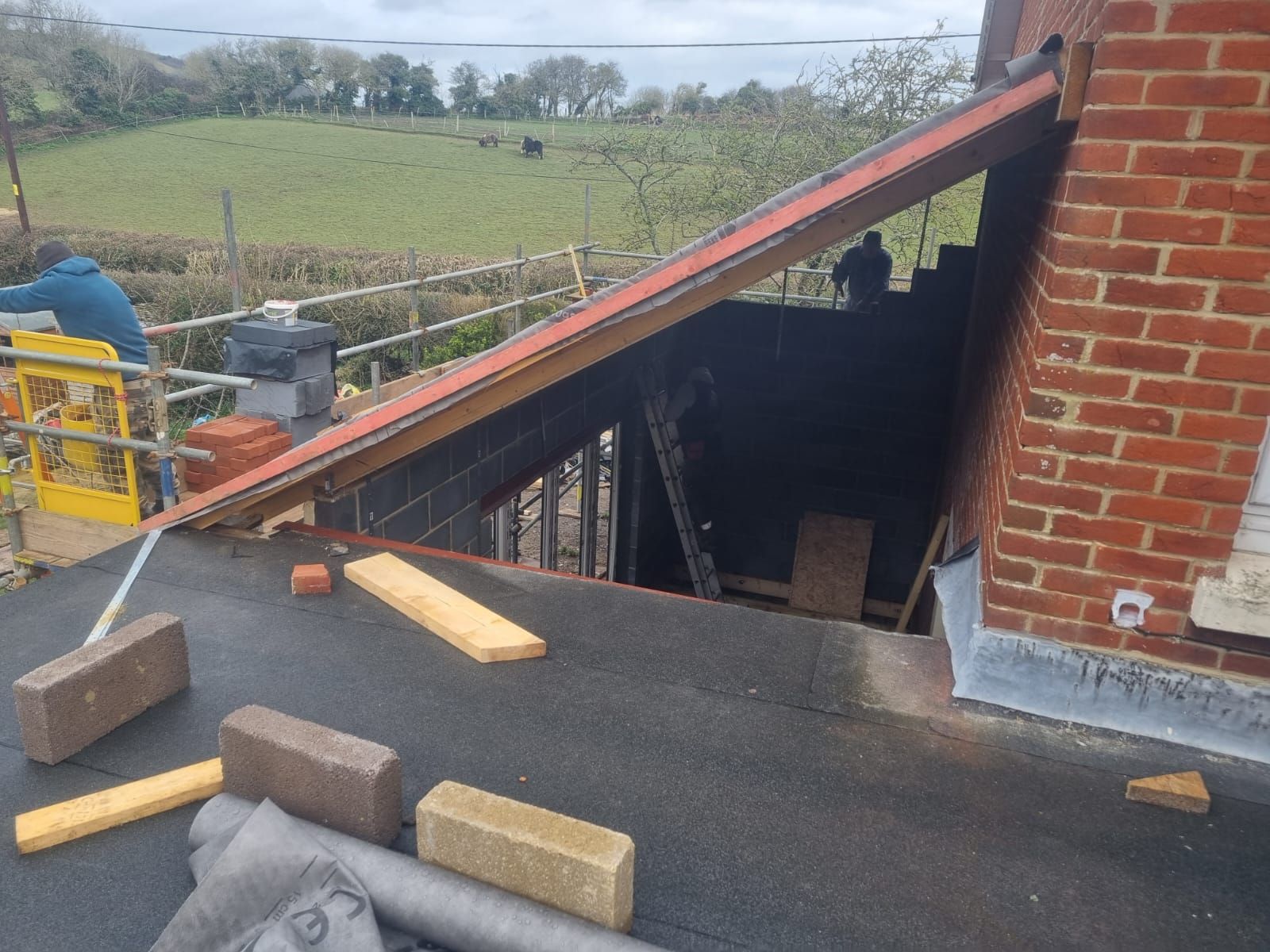 A roof is being built on top of a brick building.