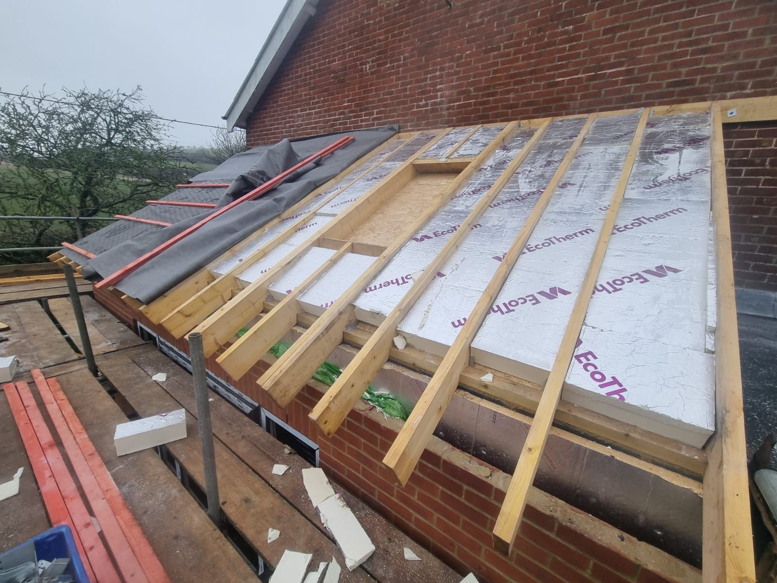 a roof is being built on top of a brick building .