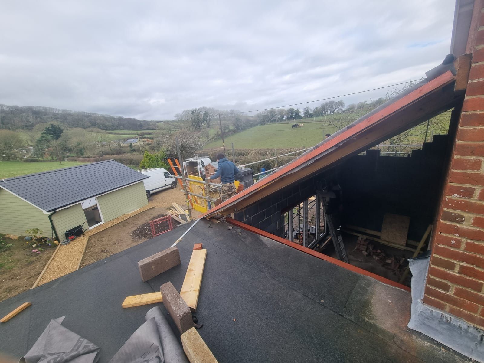 A man is working on the roof of a house.