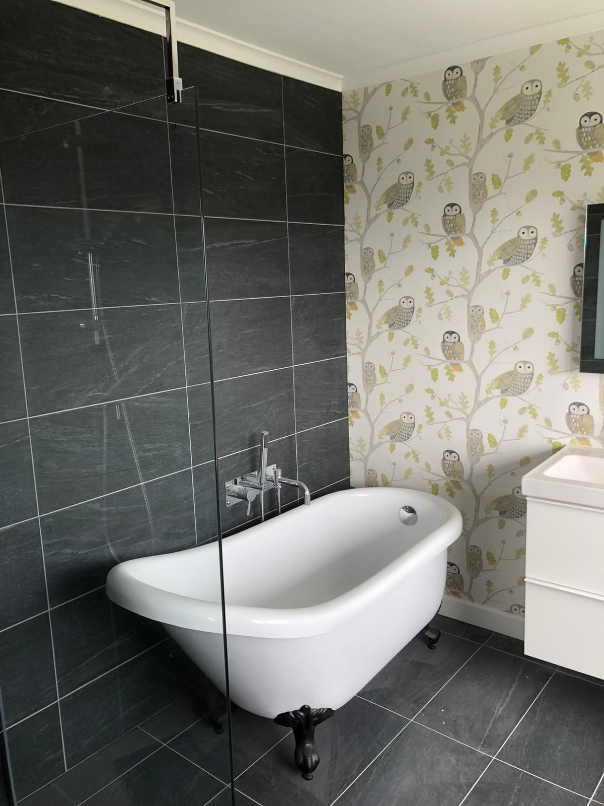 A bathroom with a bathtub , sink , and shower.