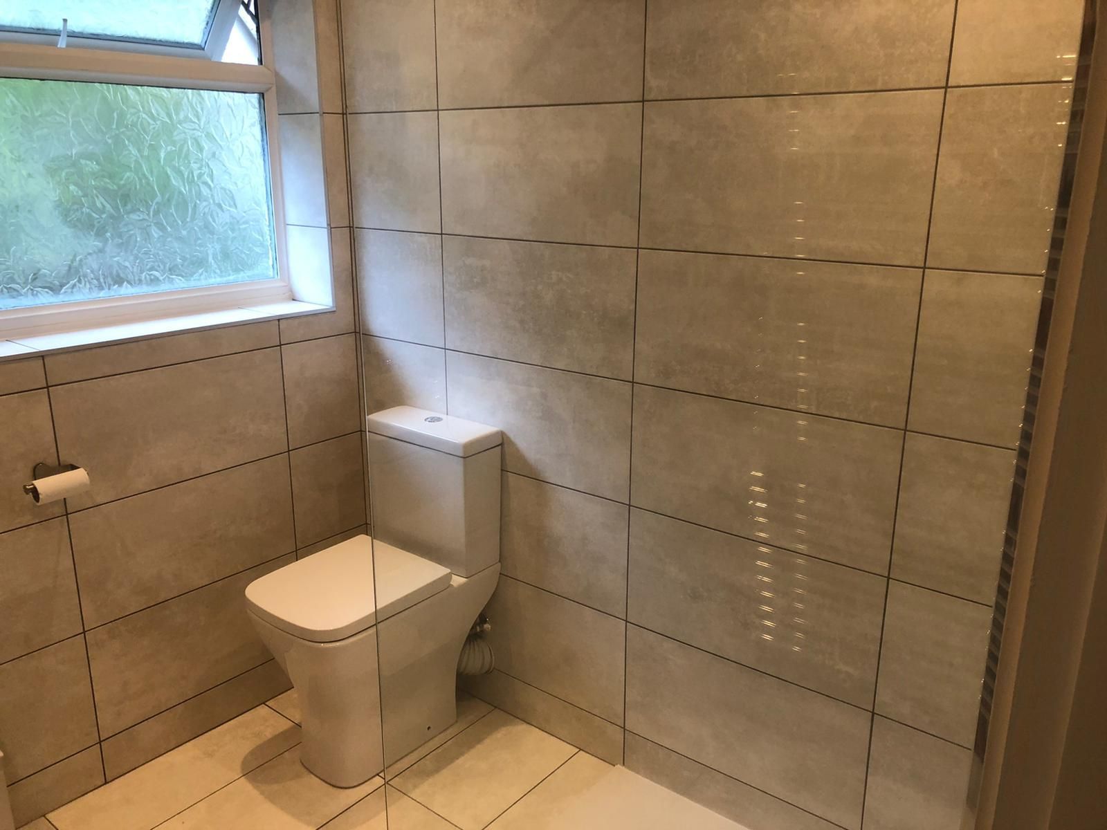 A bathroom with a toilet and a window.