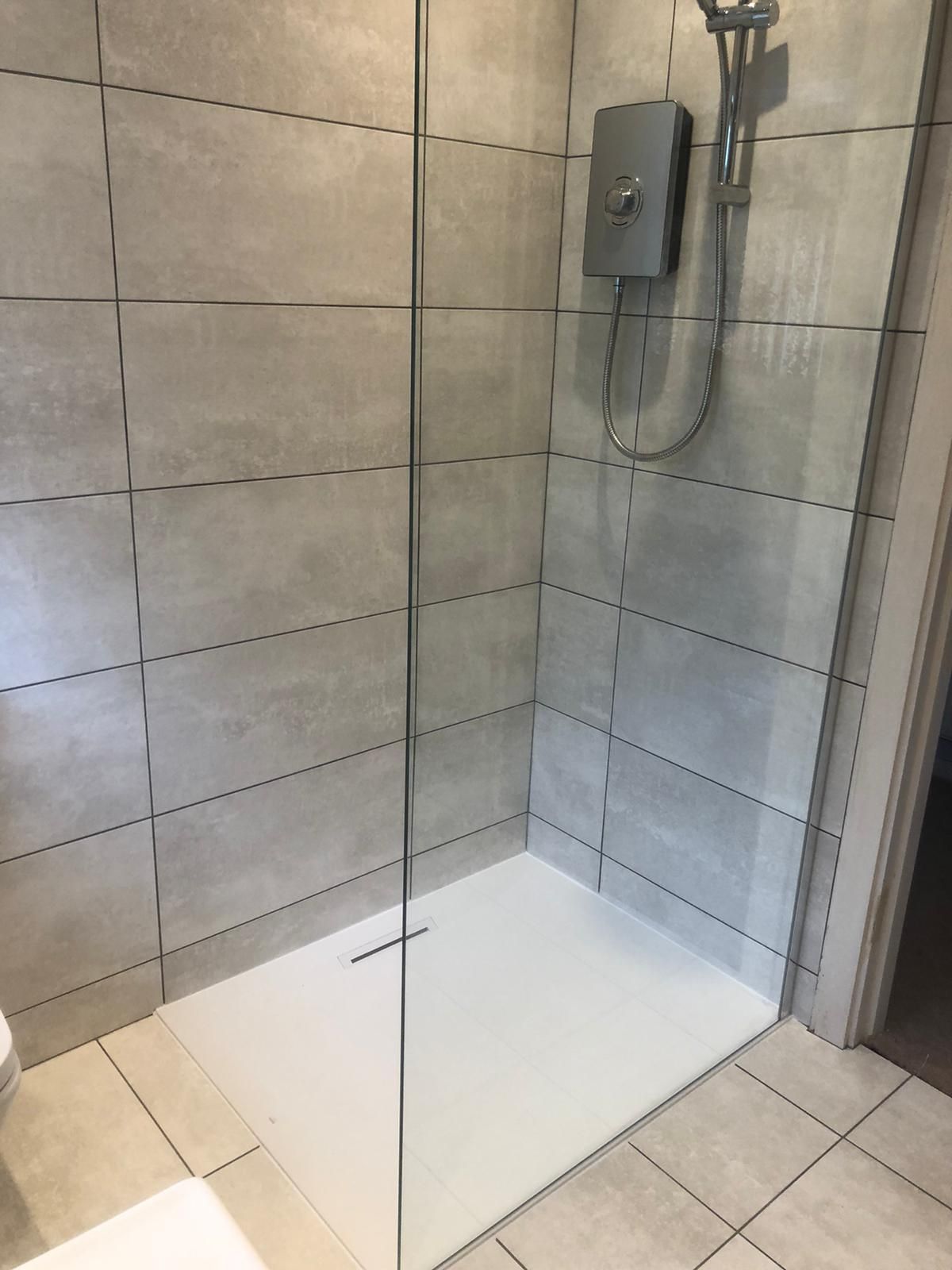 A bathroom with a walk in shower and a toilet.