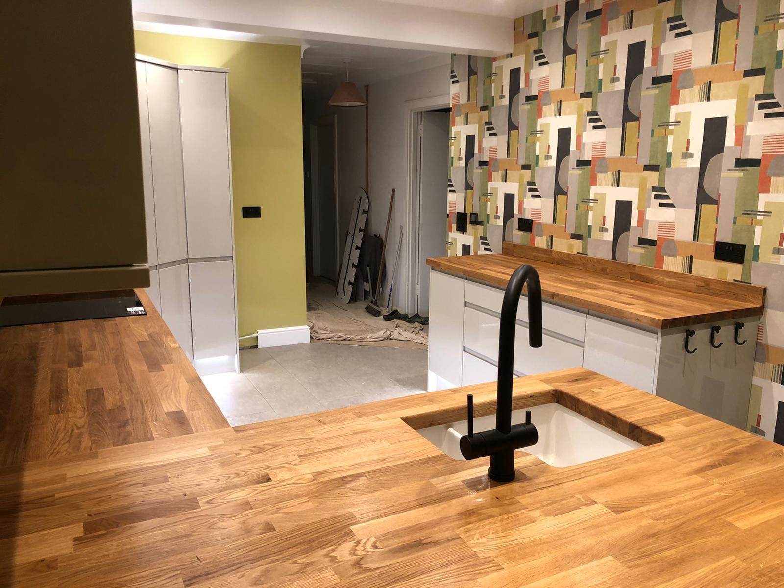 A kitchen with a sink and a wooden counter top.