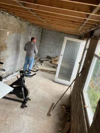 A man is standing next to an exercise bike in a room.