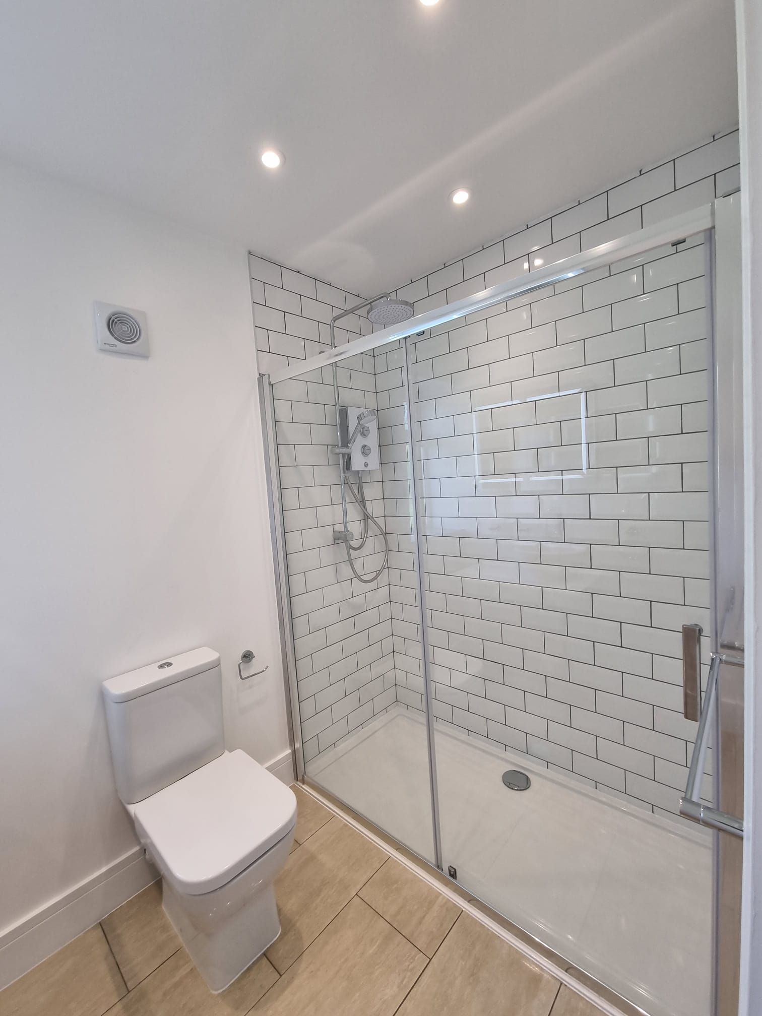 A bathroom with a toilet and a walk in shower.