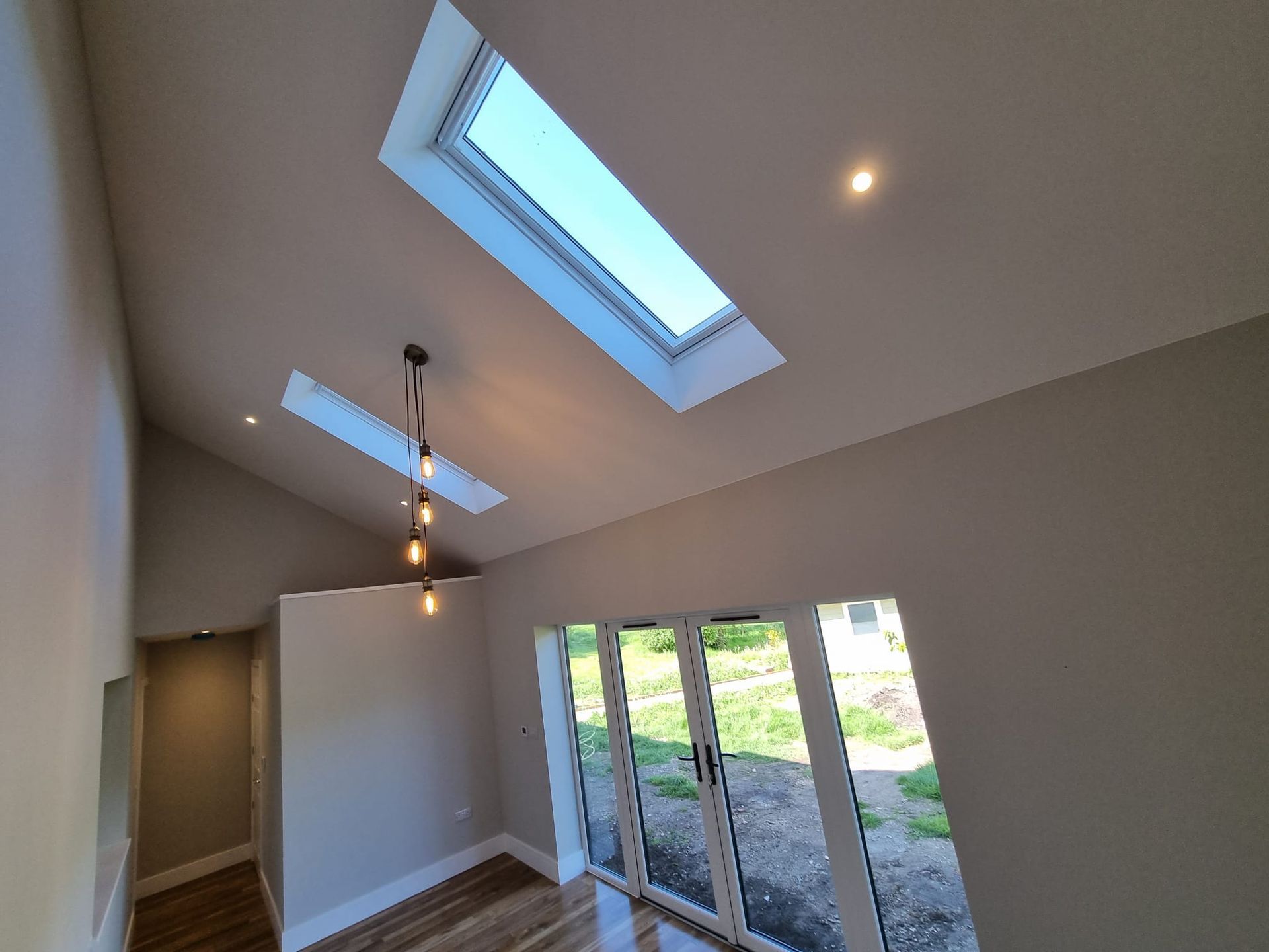 A room with a skylight and sliding glass doors