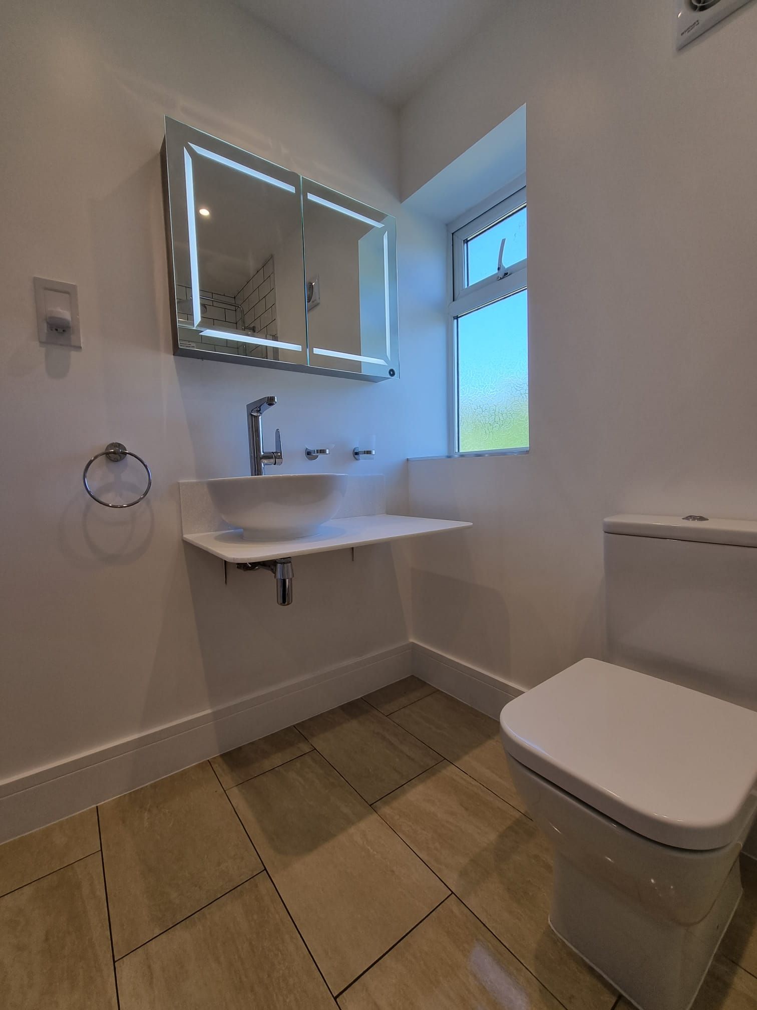 A bathroom with a sink , toilet and mirror.