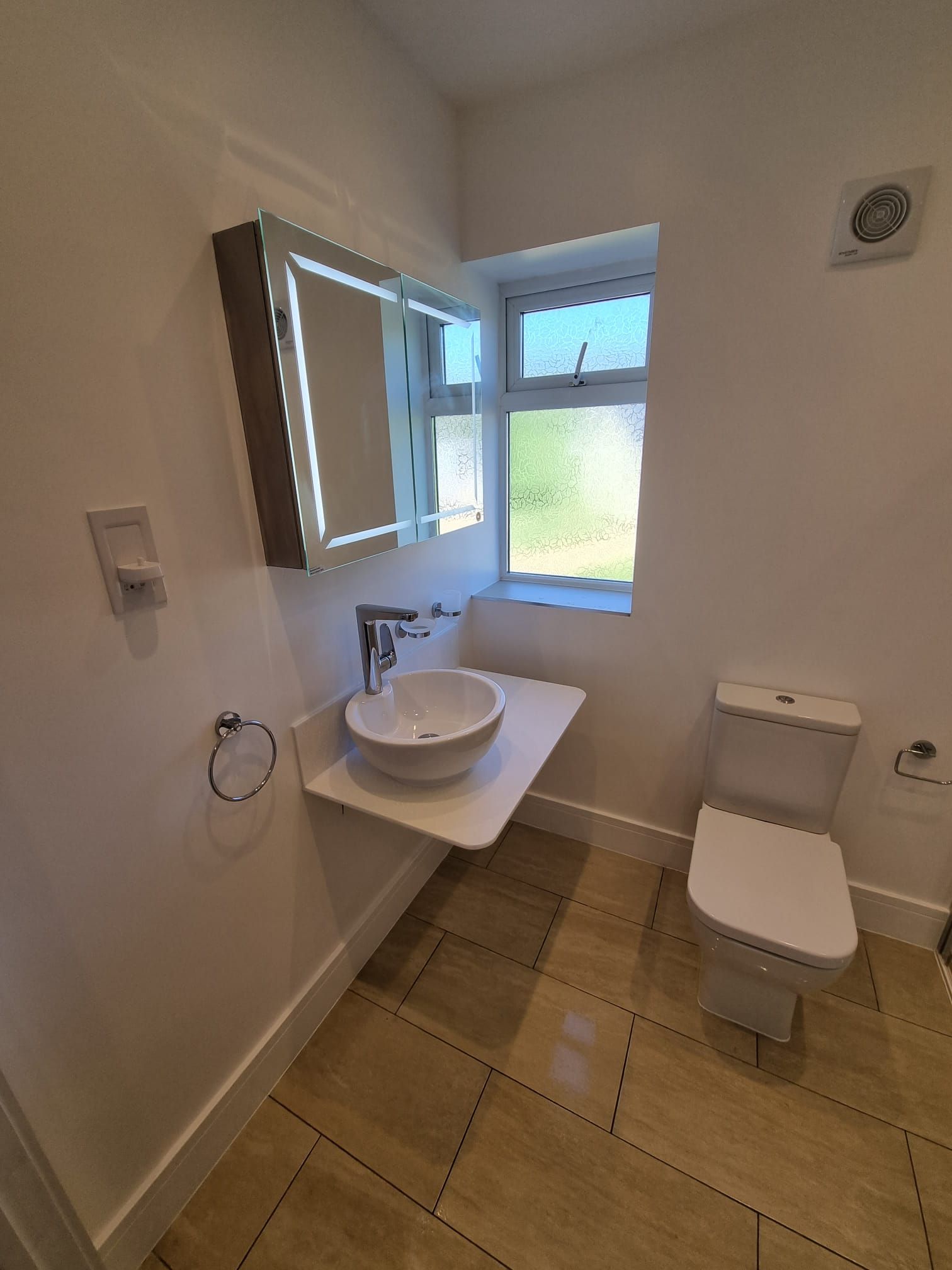A bathroom with a sink , toilet and mirror.