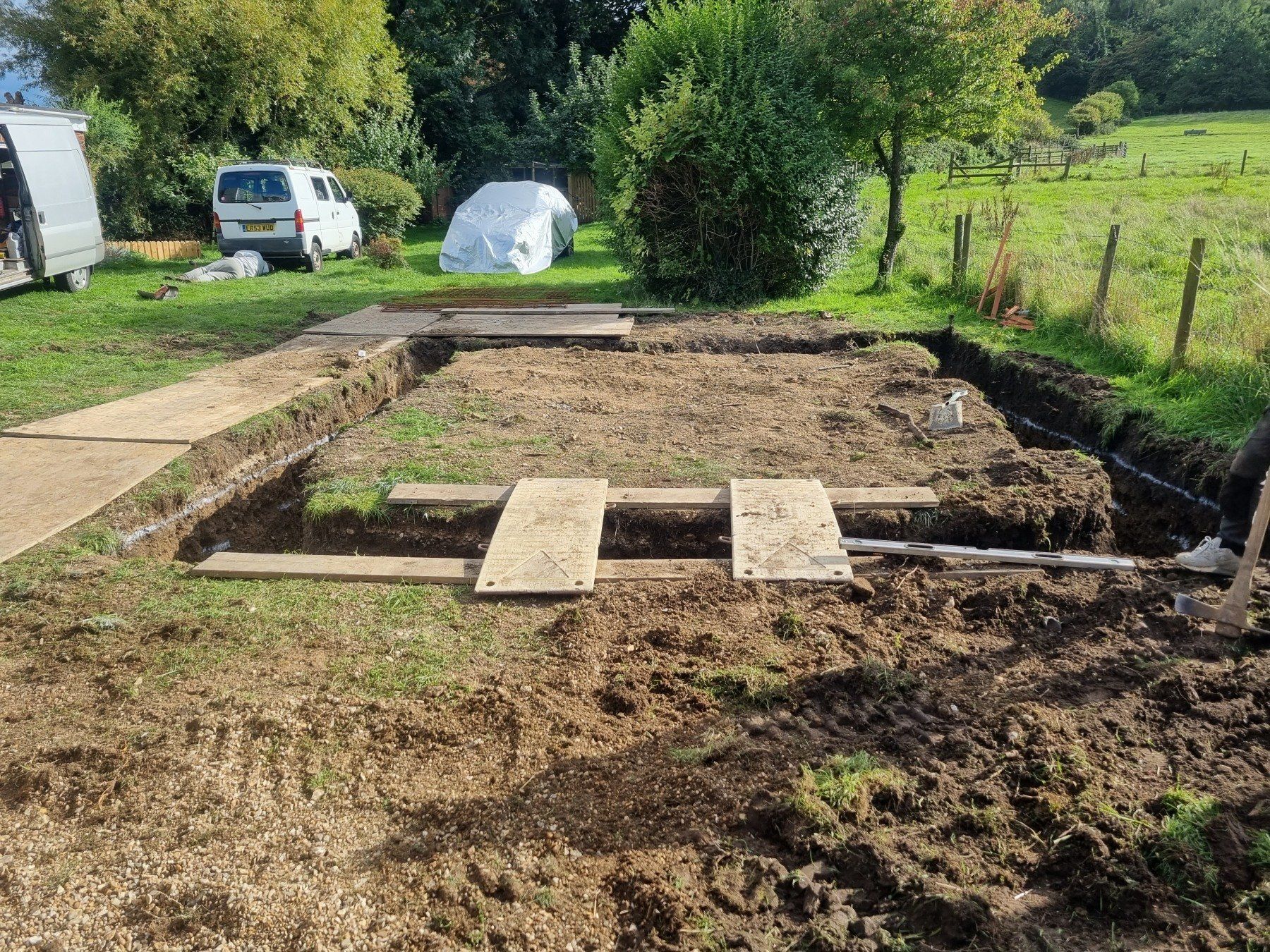 A dirt field with a white van parked in the background.