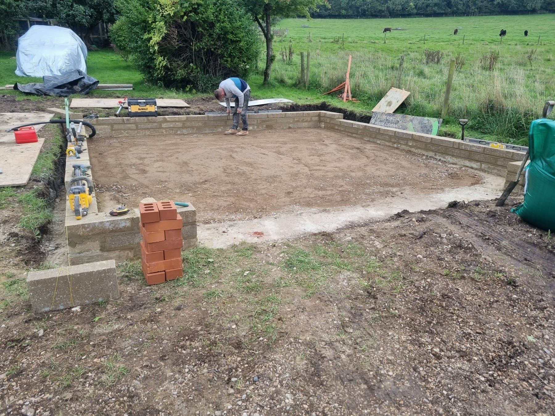 A man is working on a construction site in a field.