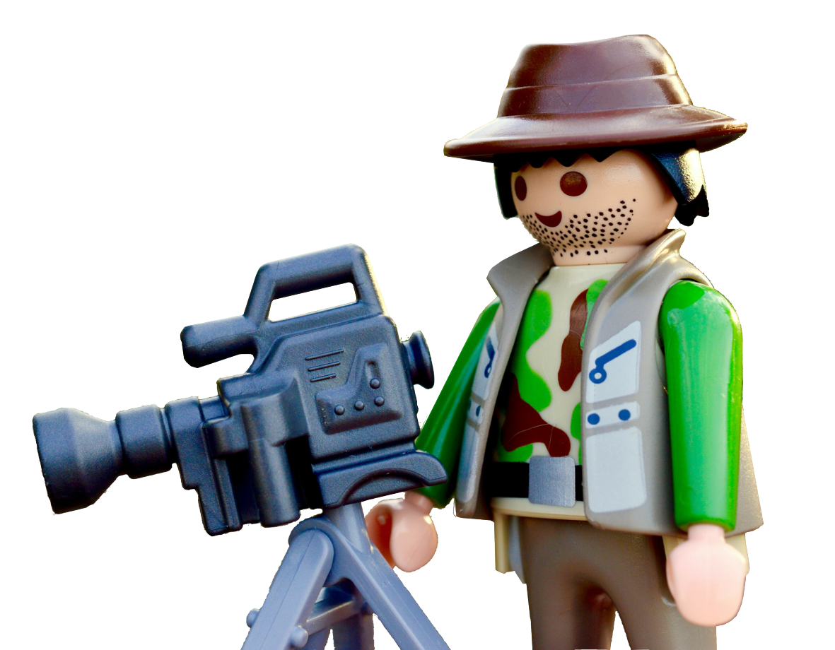 A playmobil figure is holding a camera on a tripod