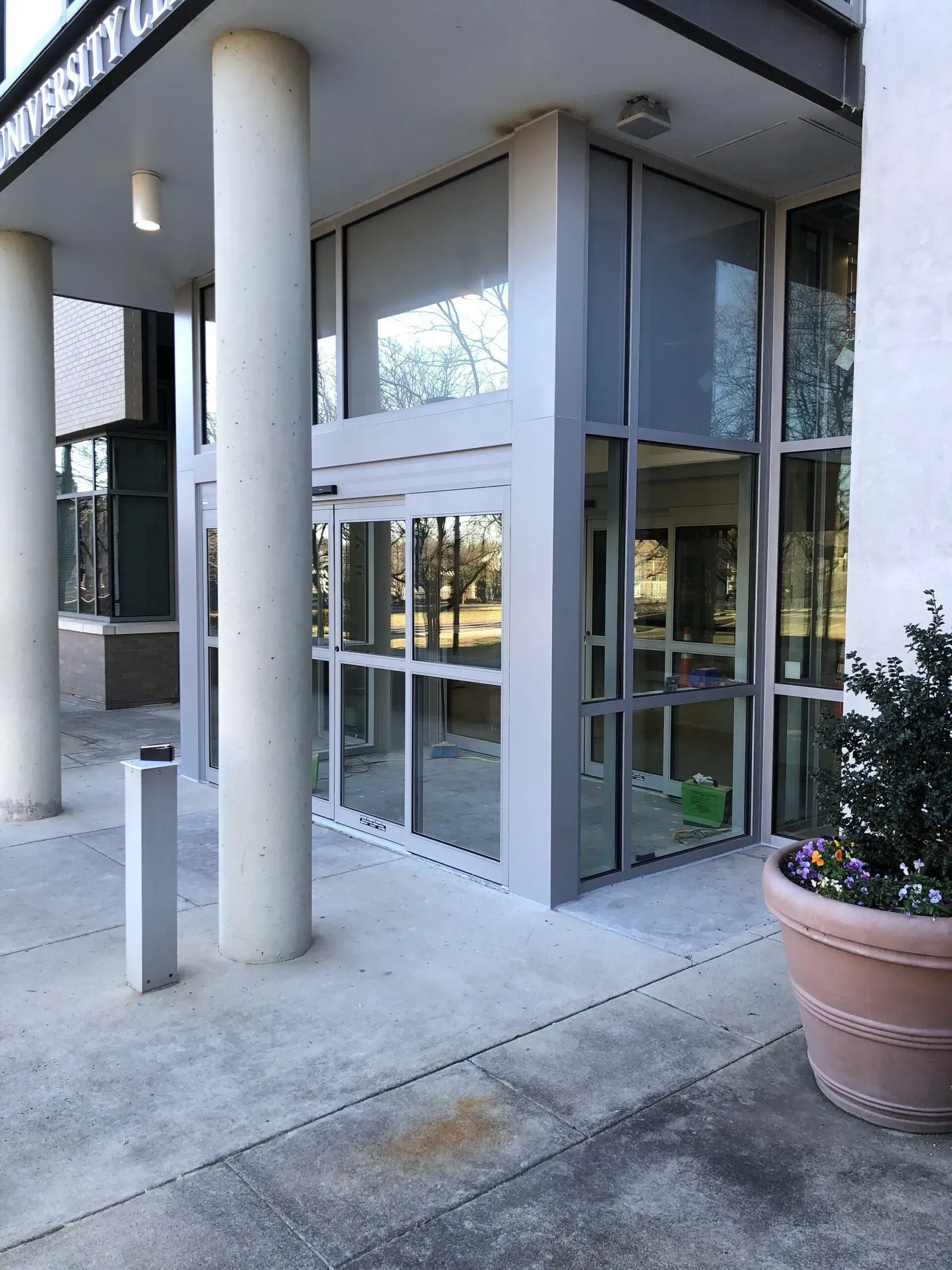 A large building with a lot of windows and a potted plant in front of it.