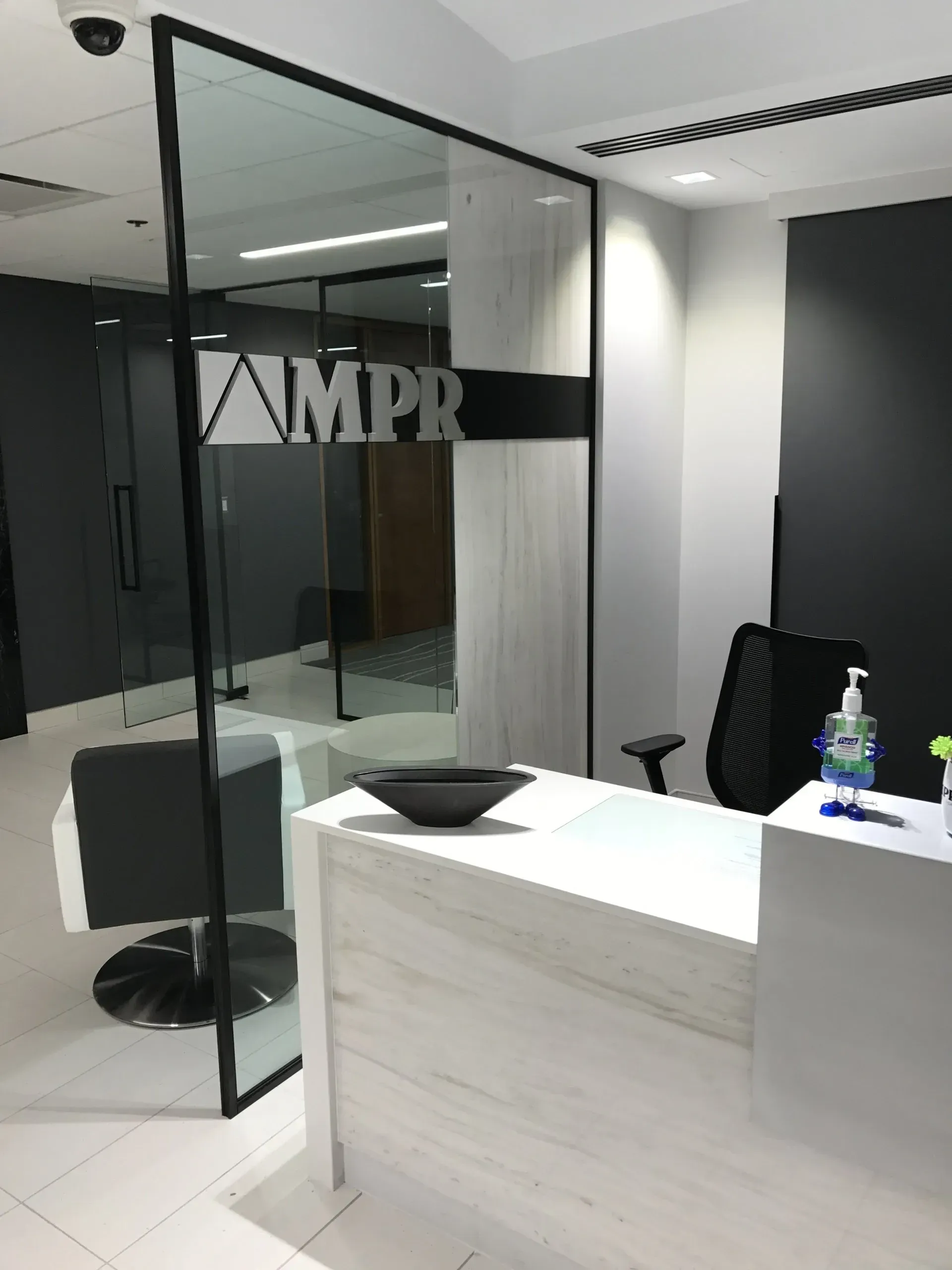 A reception area with a glass wall and a sign that says ampr