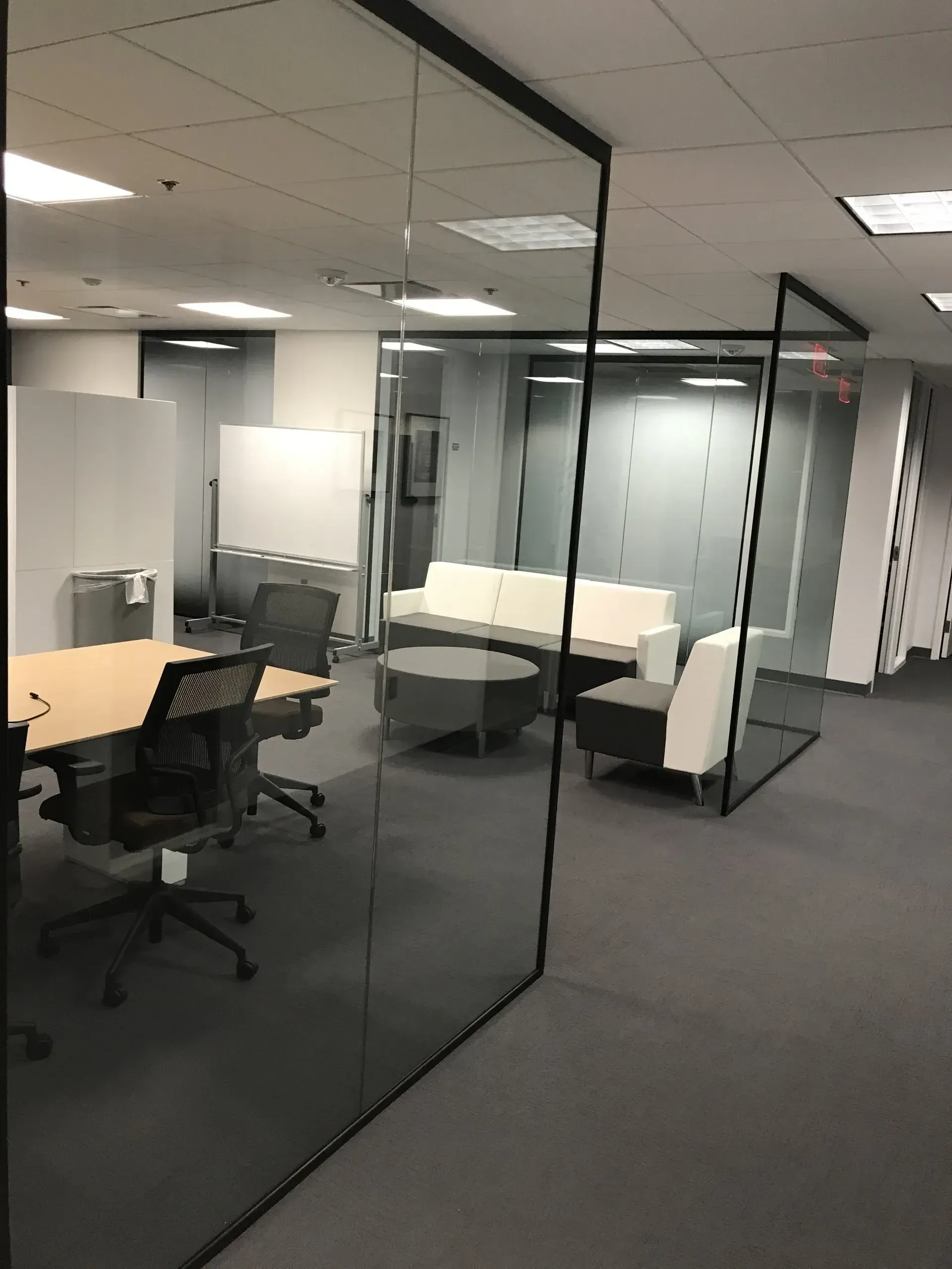 A conference room with a glass wall and a couch.