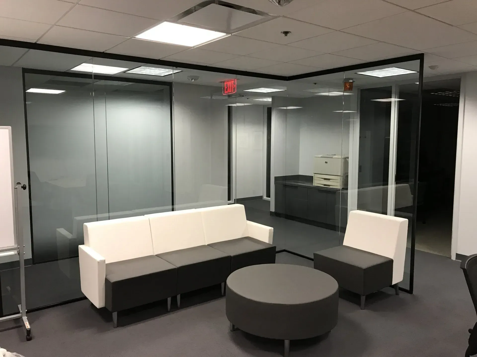 A waiting room with a couch , chairs and a round table.