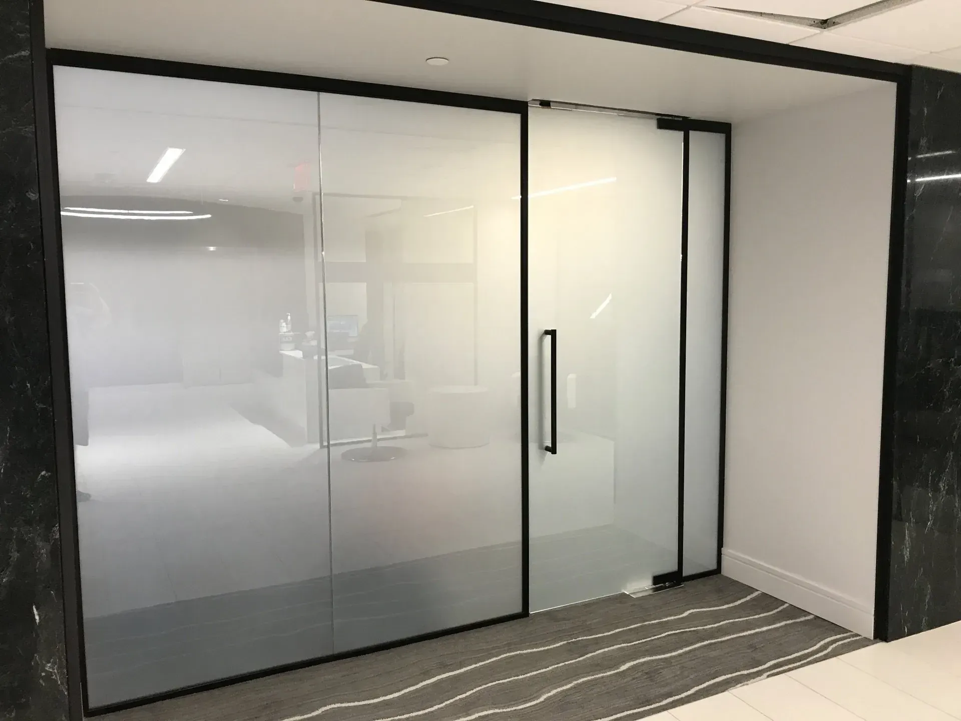 A room with a sliding glass door and a black frame.