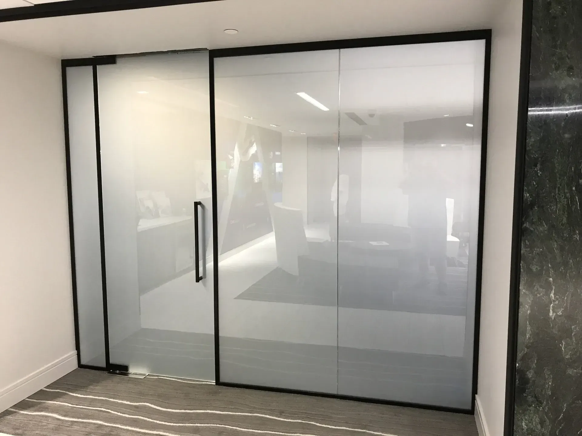 A room with sliding glass doors and a marble wall.