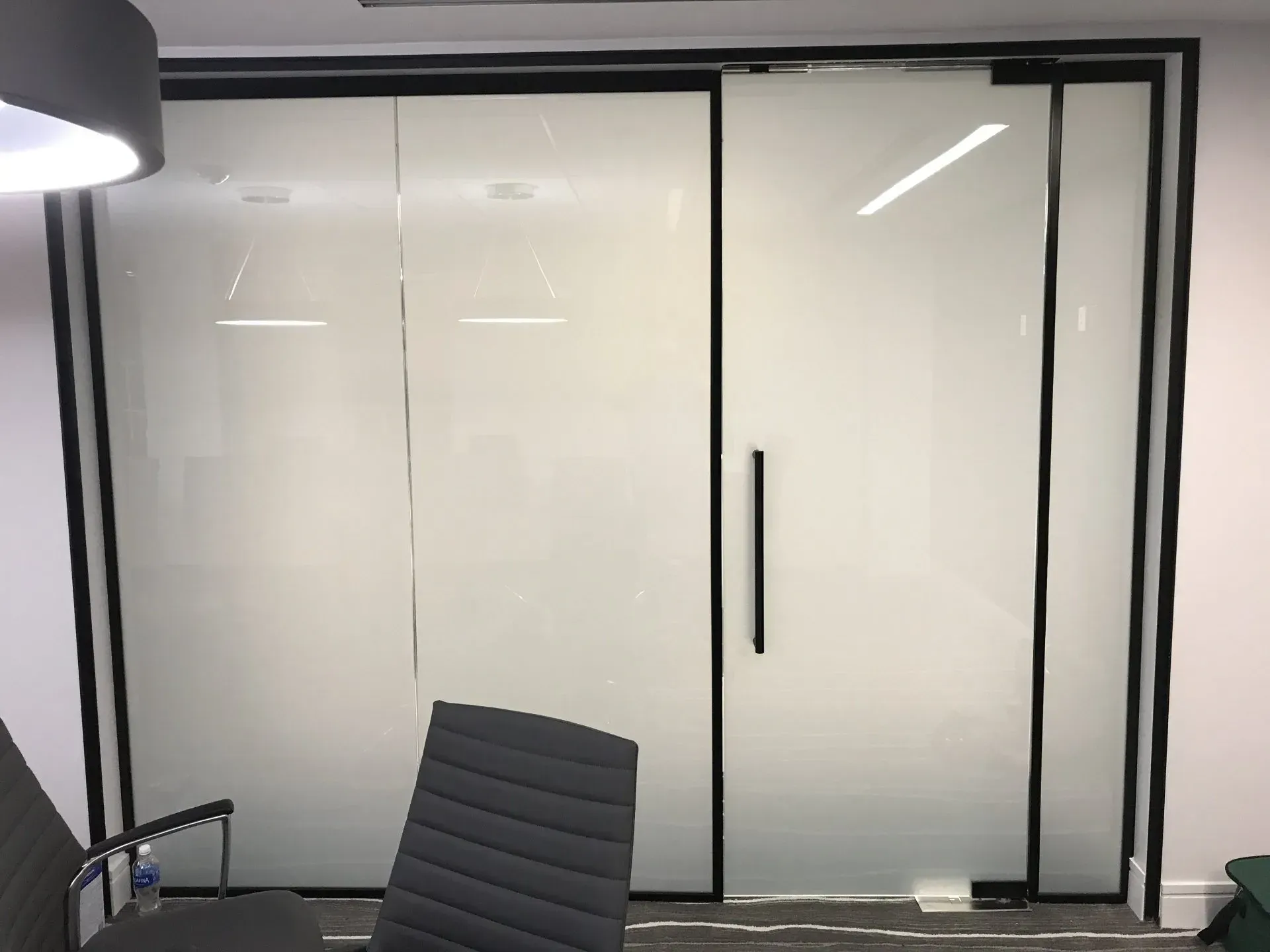 There is a chair in front of a glass door.