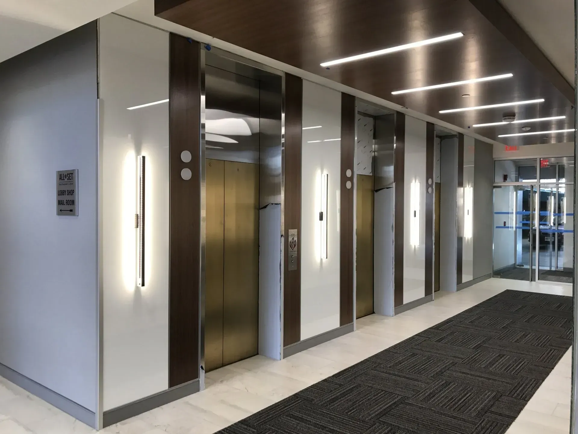 A long hallway with elevators in a building.