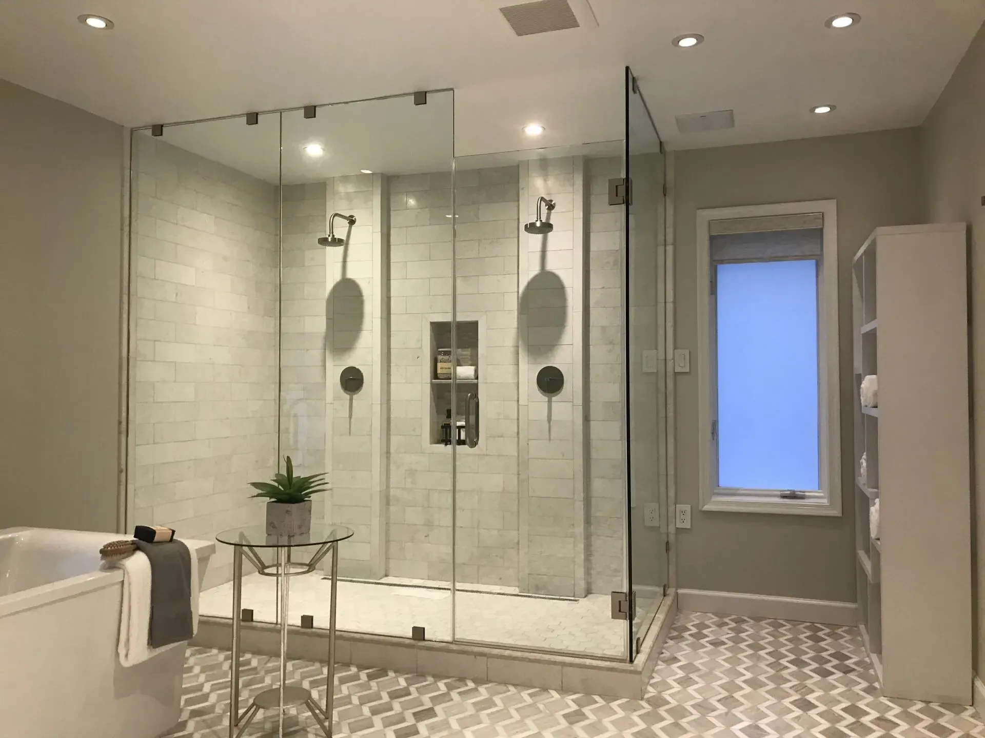 A bathroom with a walk in shower and a tub.