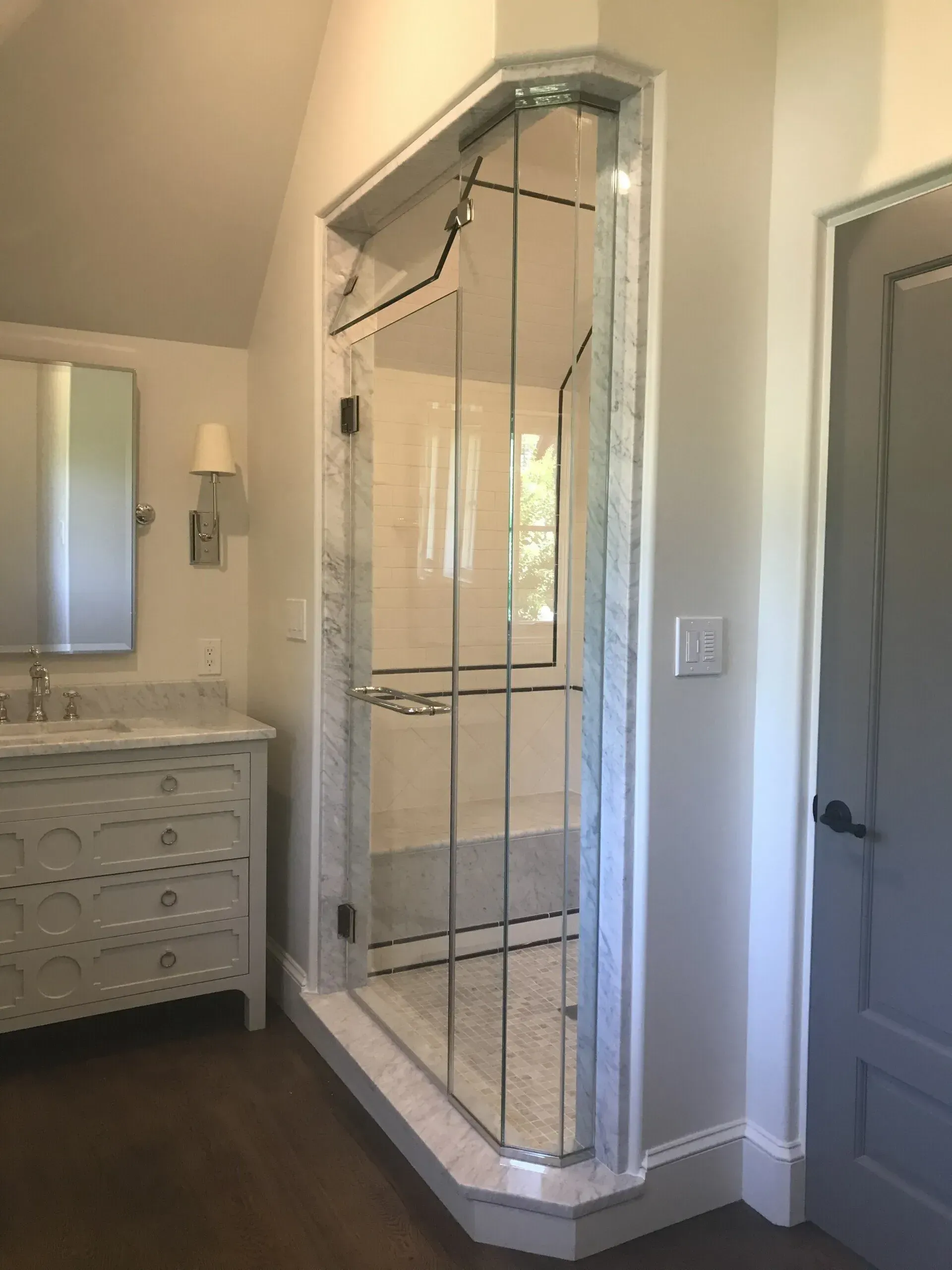 A bathroom with a walk in shower and a sink