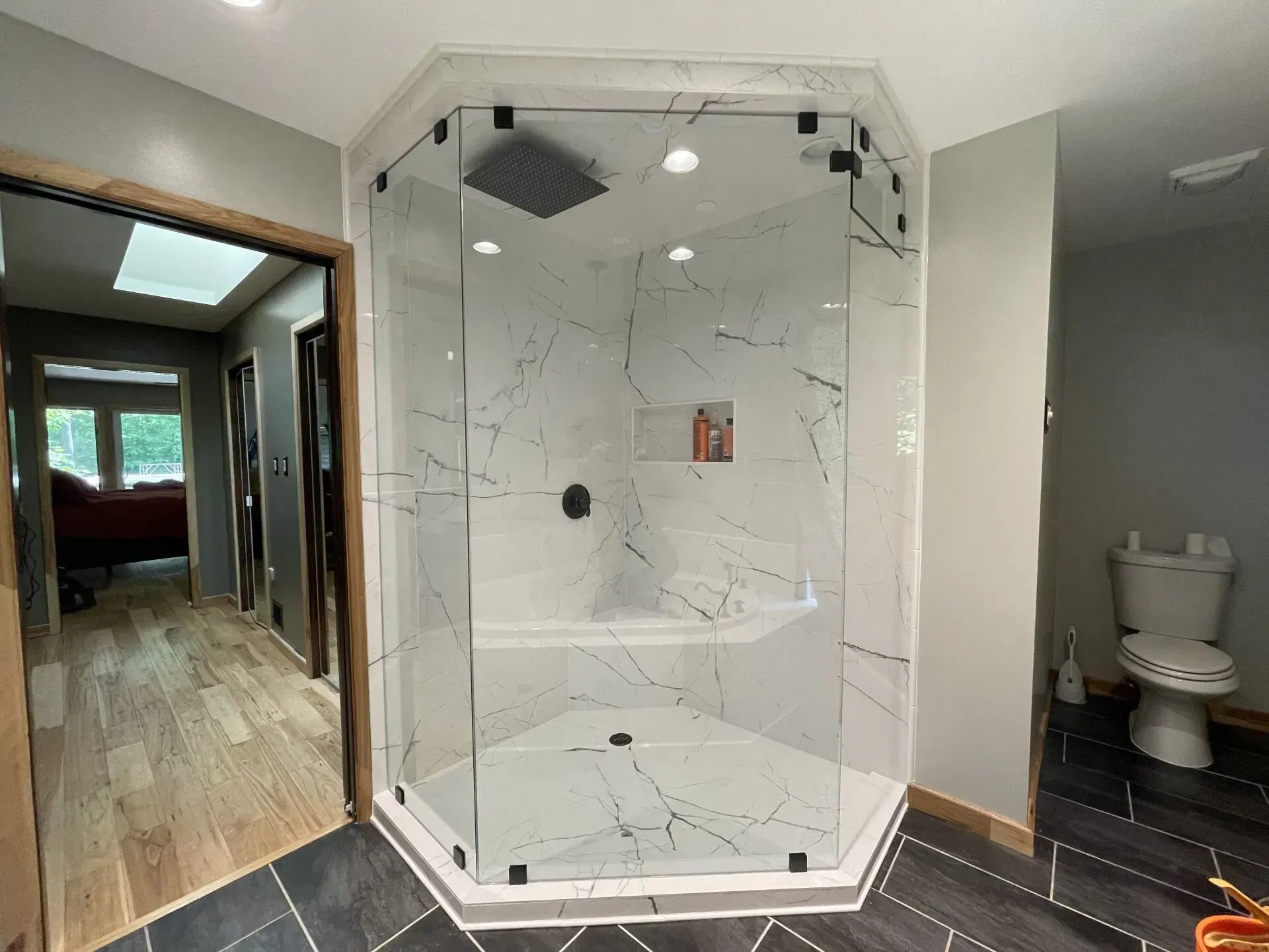 A bathroom with a walk in shower and a toilet.