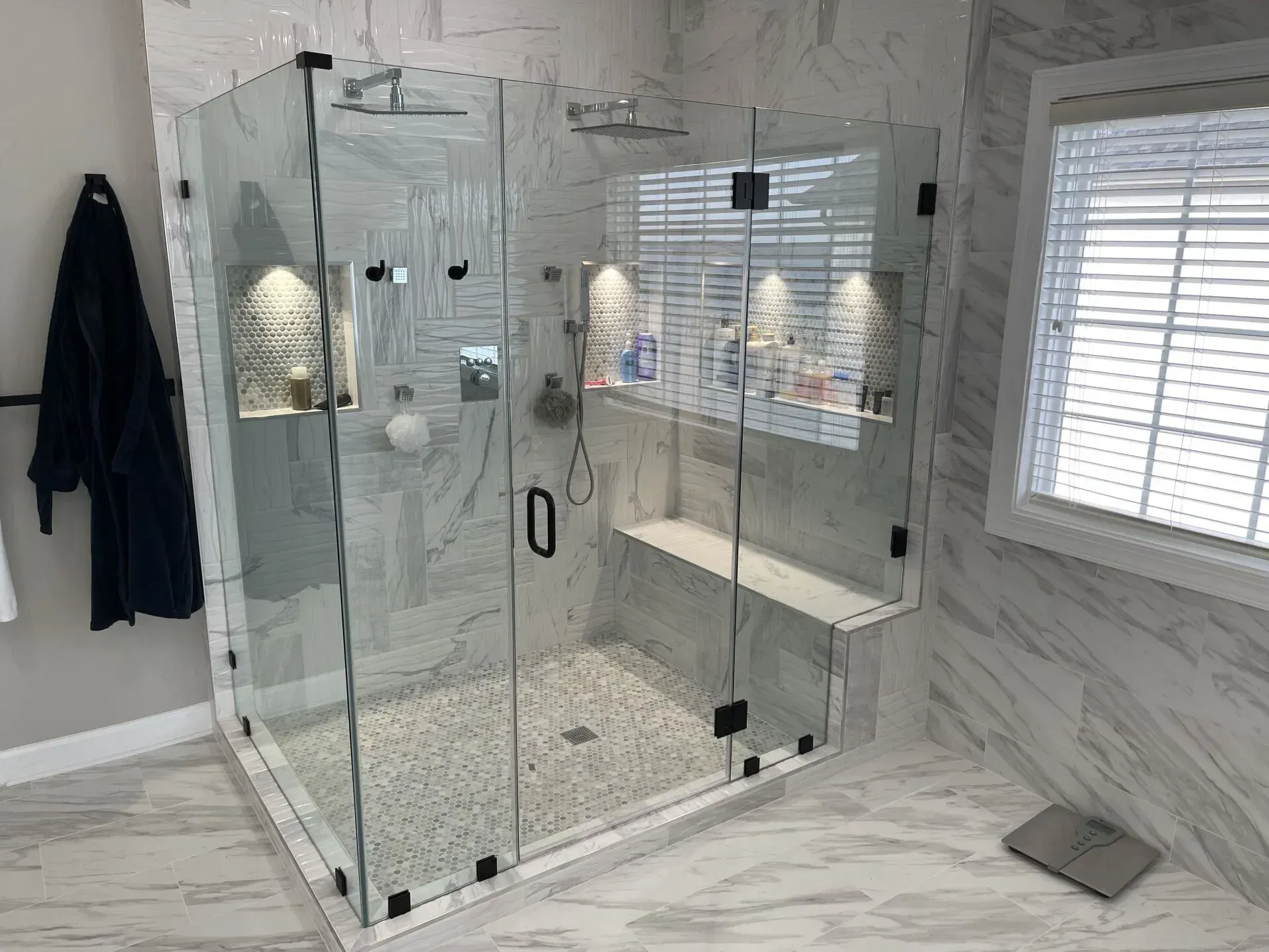 A bathroom with a walk in shower and a window.