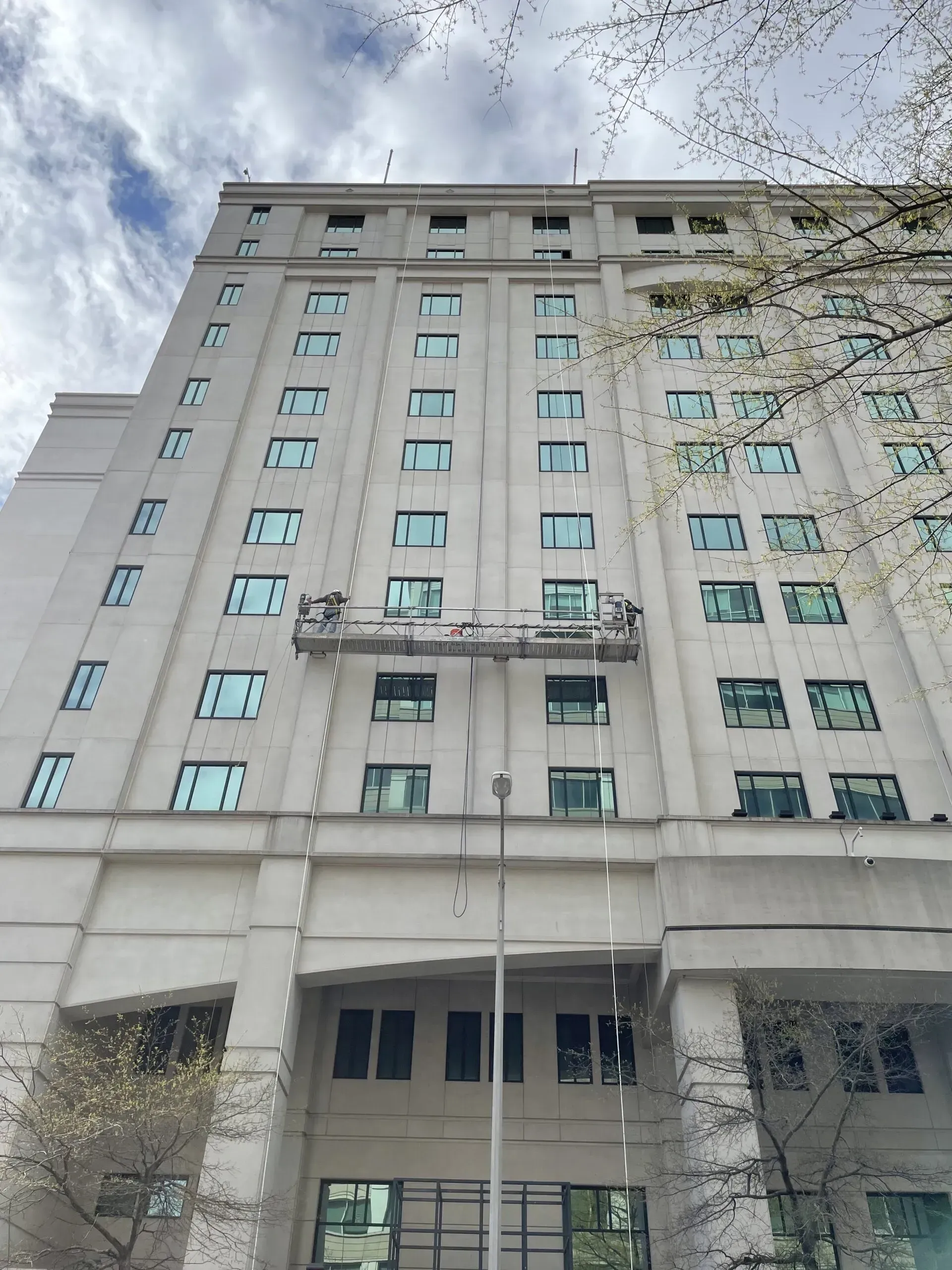 A large building with a lot of windows is being painted