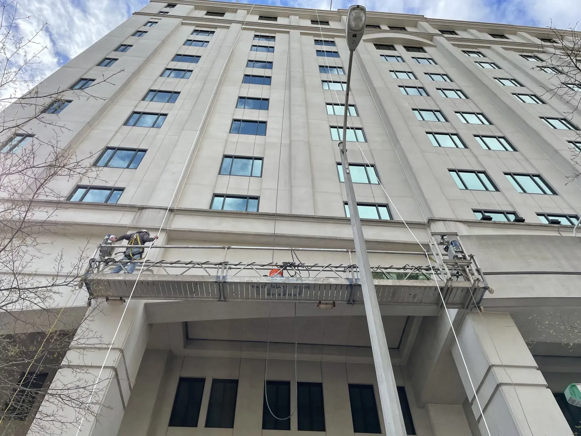 A large building with a lot of windows is being painted