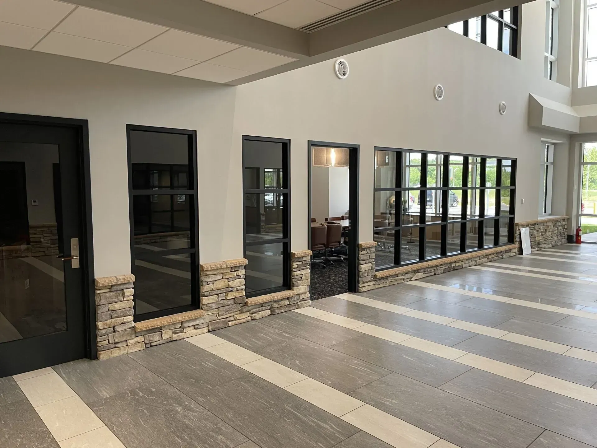 A large hallway with a lot of windows and doors in a building.
