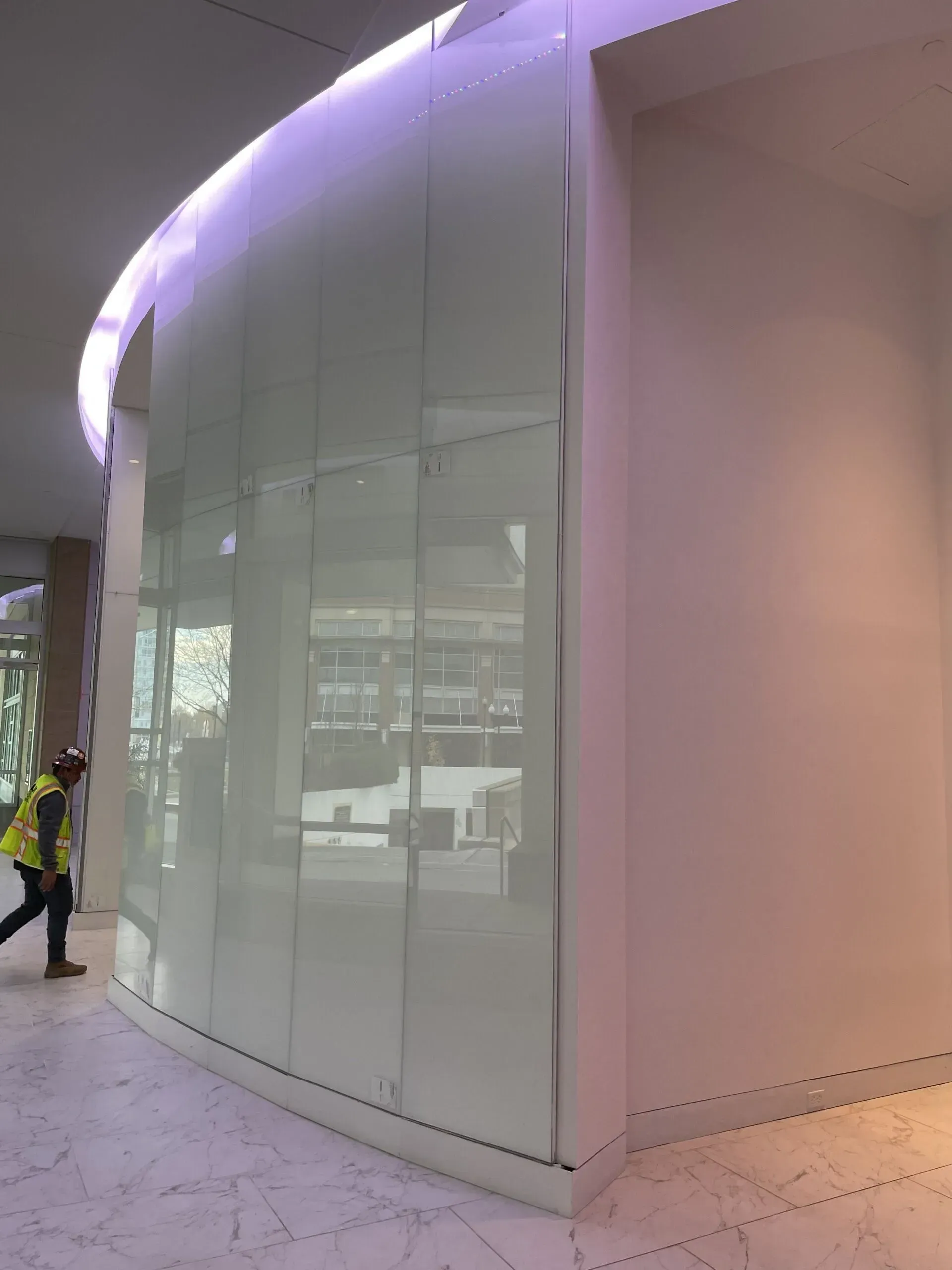 A person is standing in a room with a curved wall.